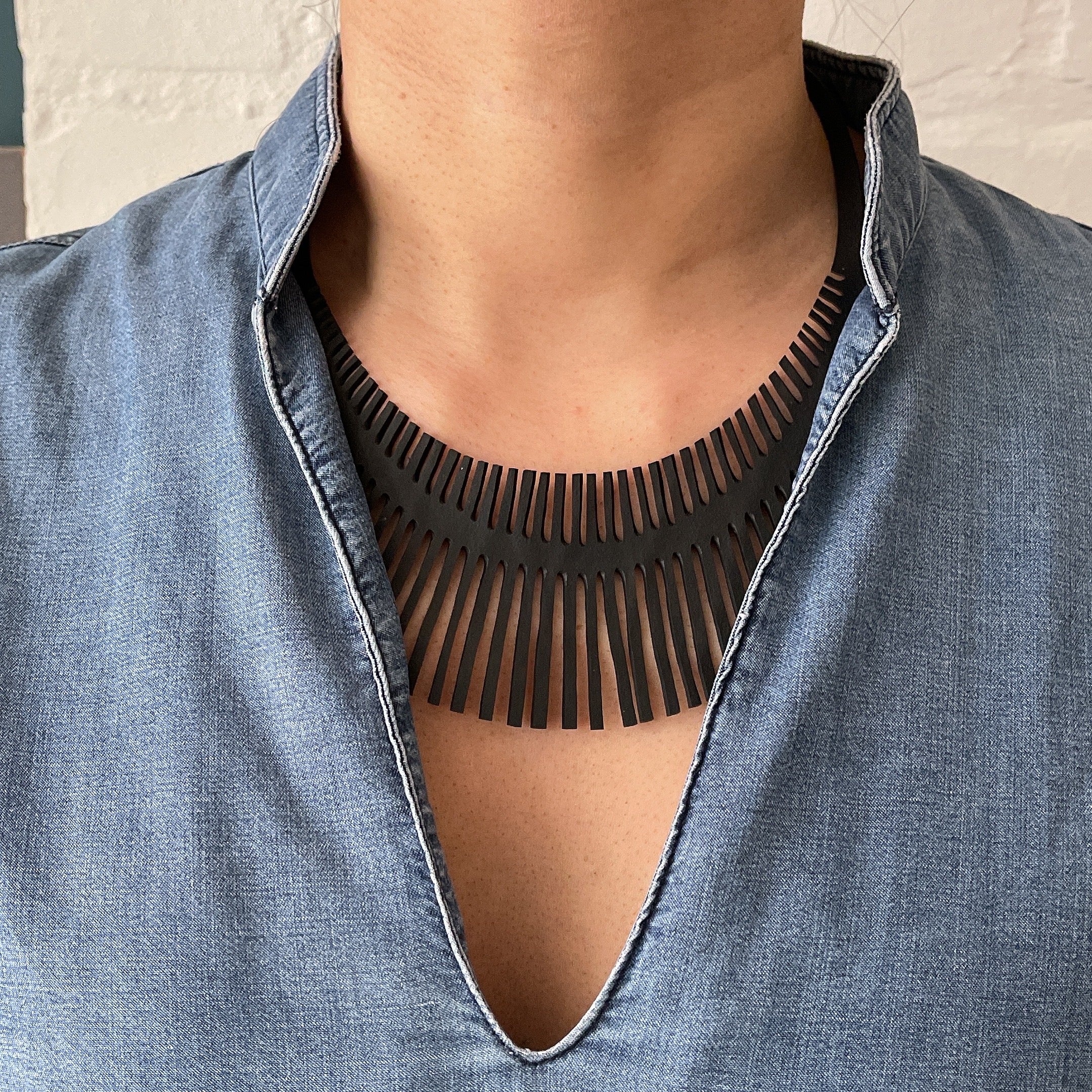 Fishbone Inner Tube Necklace made from reclaimed rubber, featuring a playful design and lightweight construction, ideal for eco-conscious fashion.