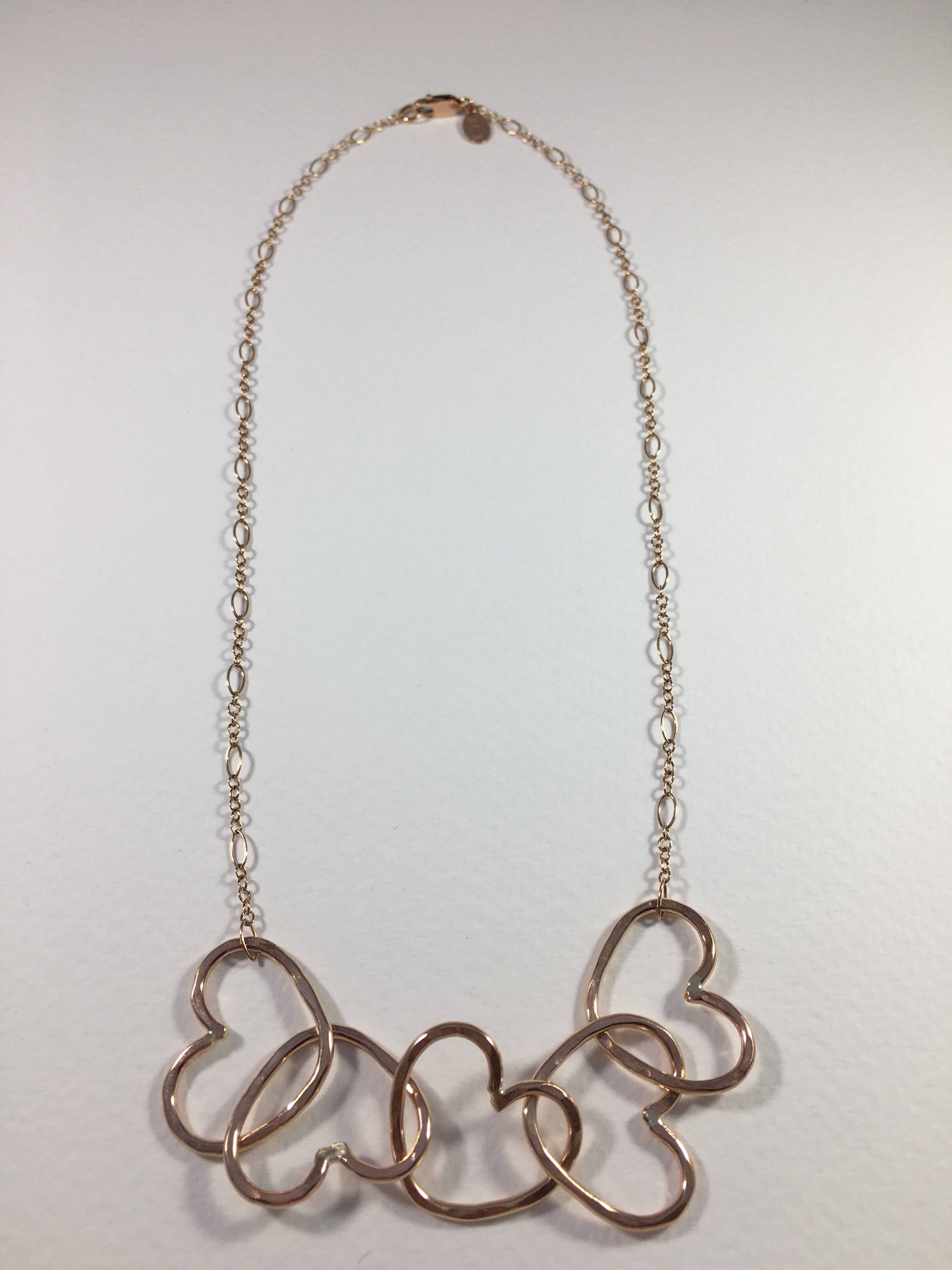 Five Hearts Linked Necklace showcasing five unique hearts linked together in polished rose gold fill metal.