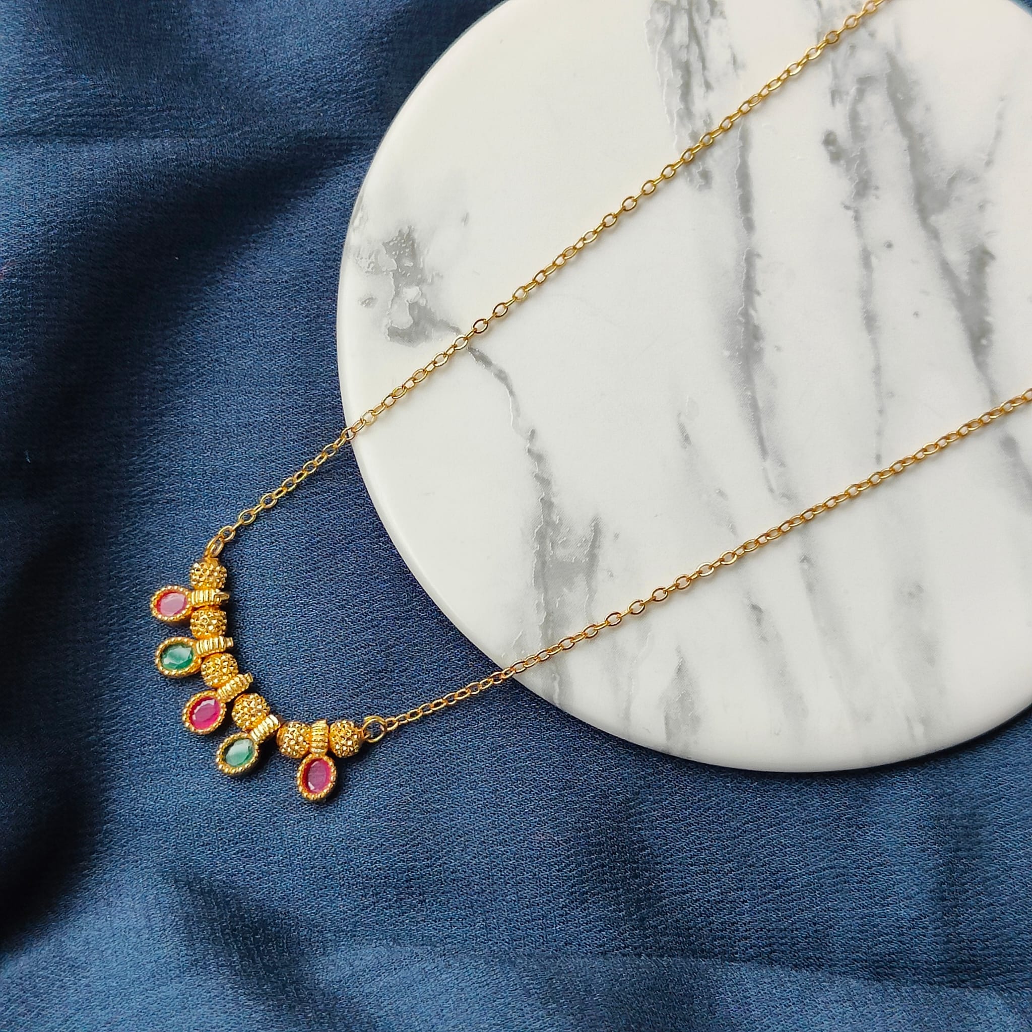 Five Stone Dangle Necklace featuring colorful stones on a gold brass chain, elegantly designed for modern women.