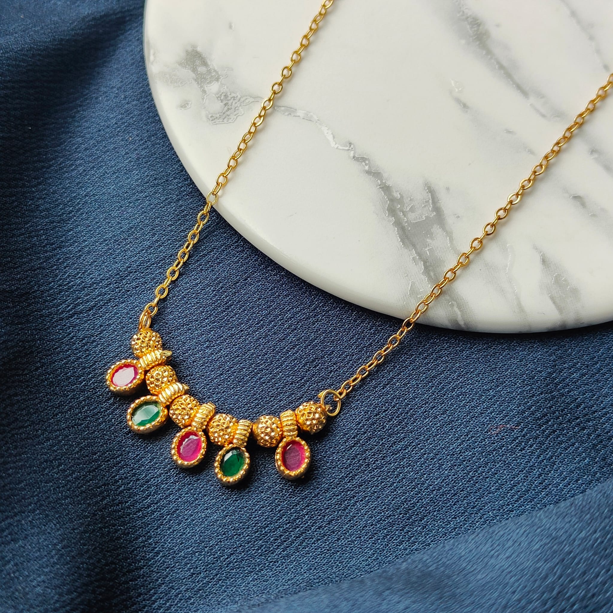 Five Stone Dangle Necklace featuring colorful stones on a gold brass chain, elegantly designed for modern women.