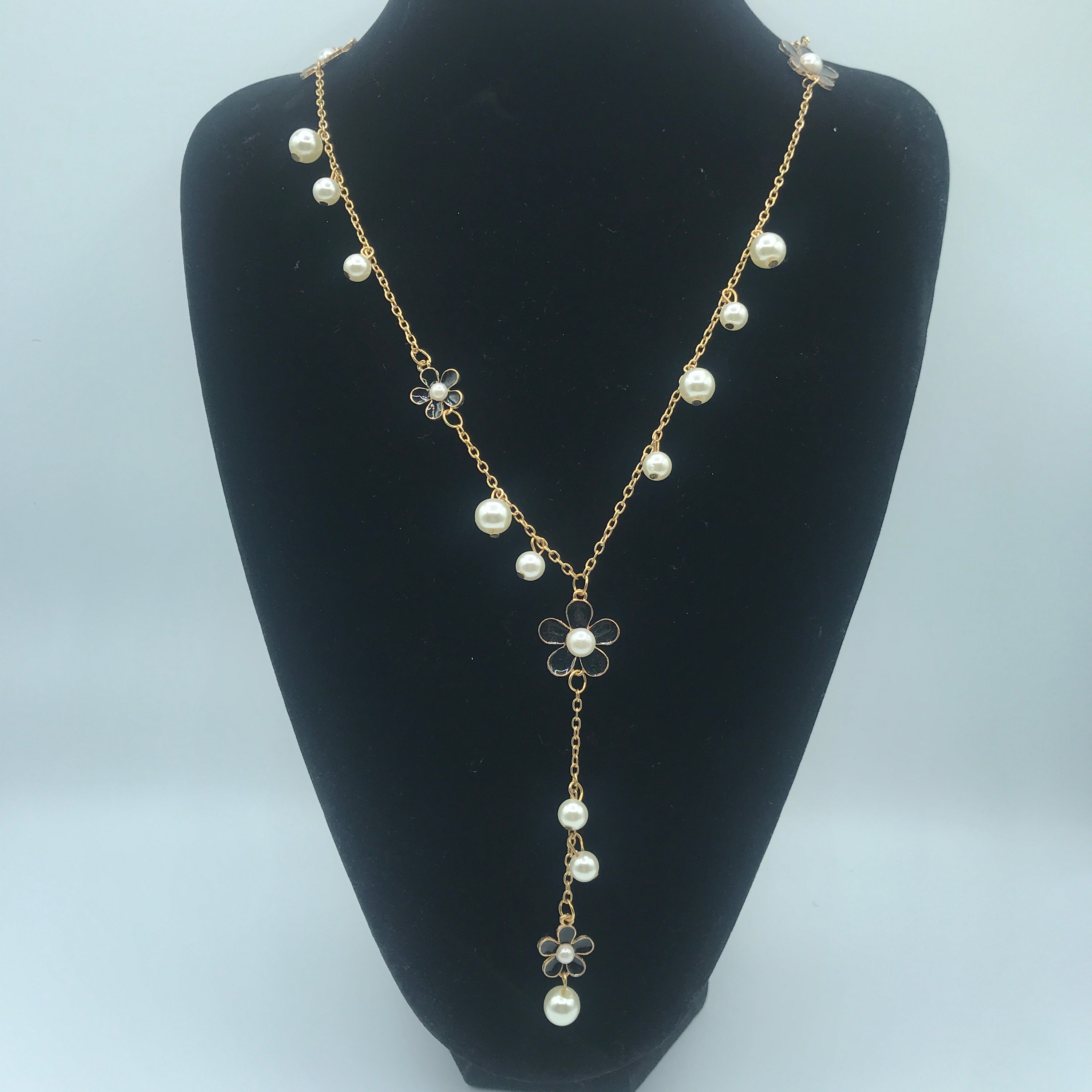 A beautiful five-petal flower necklace adorned with pearls, showcasing elegance and charm, perfect for sweaters.