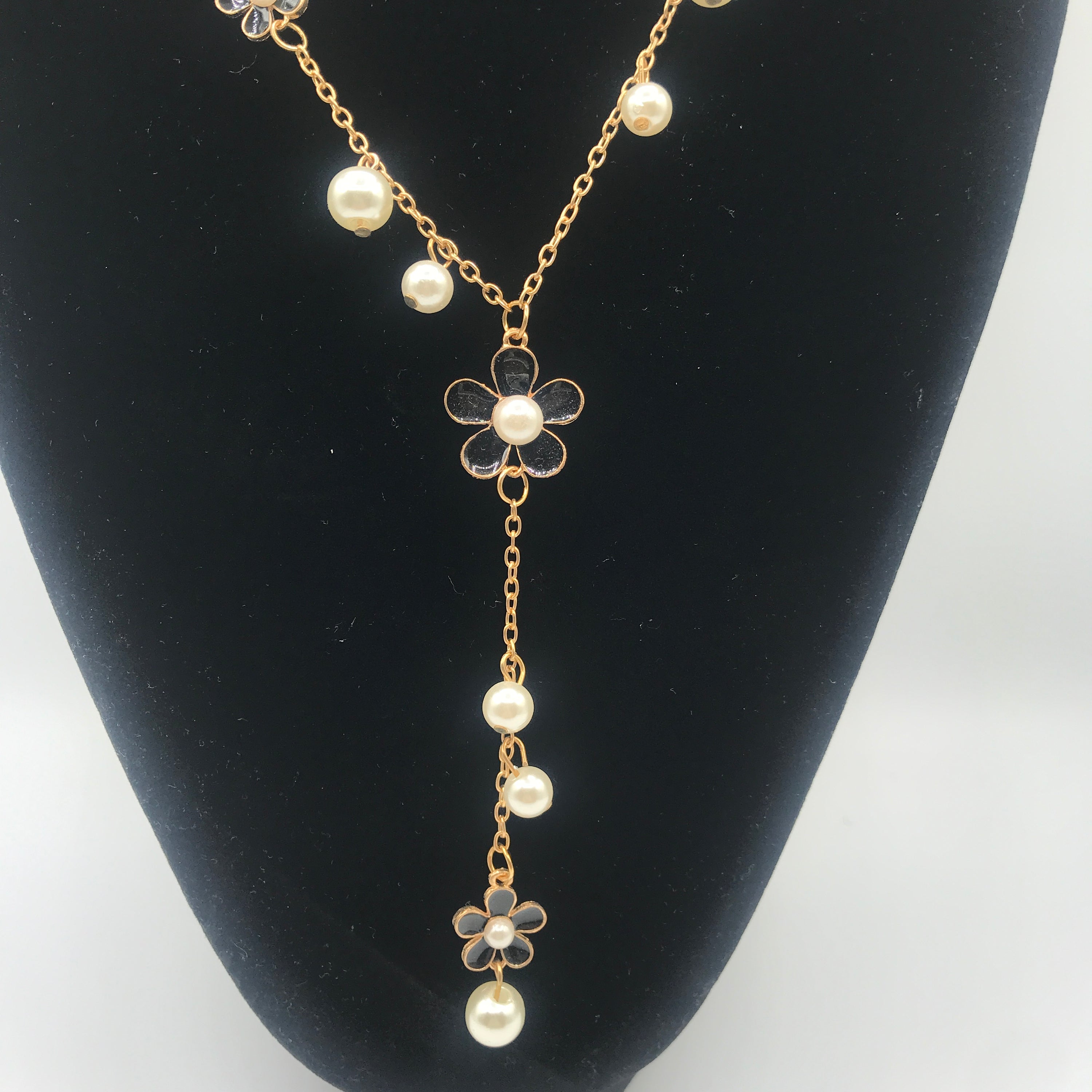 A beautiful five-petal flower necklace adorned with pearls, showcasing elegance and charm, perfect for sweaters.