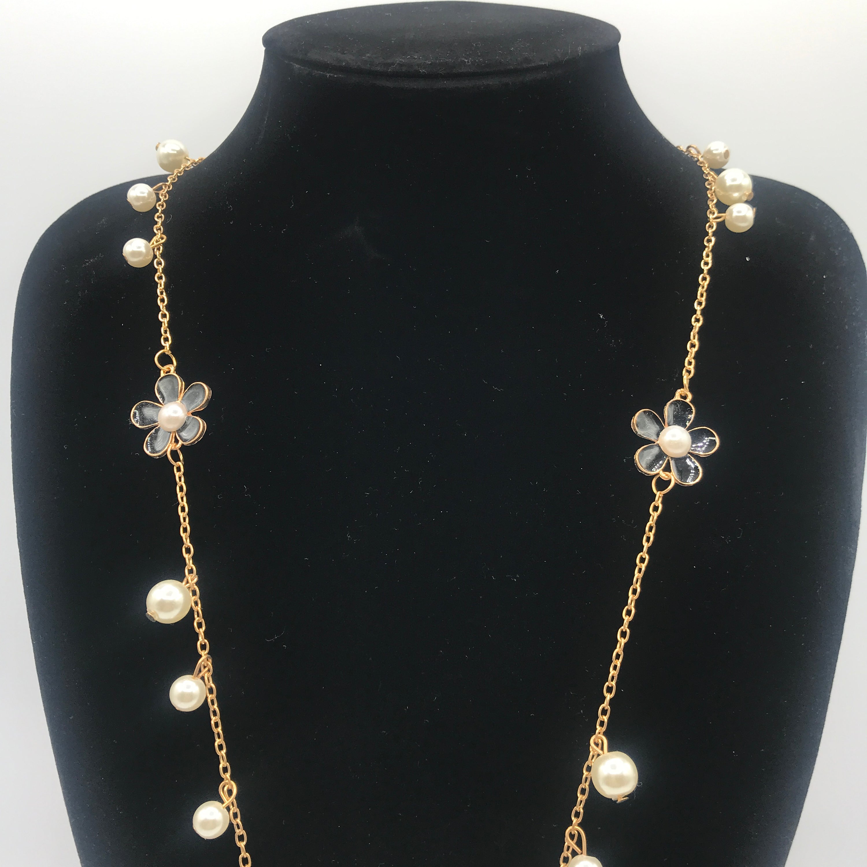 A beautiful five-petal flower necklace adorned with pearls, showcasing elegance and charm, perfect for sweaters.