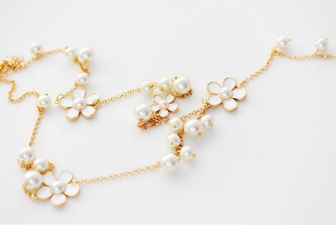 A beautiful five-petal flower necklace adorned with pearls, showcasing elegance and charm, perfect for sweaters.