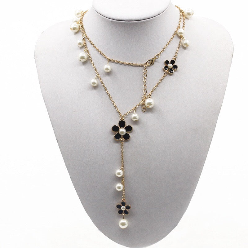 A beautiful five-petal flower necklace adorned with pearls, showcasing elegance and charm, perfect for sweaters.