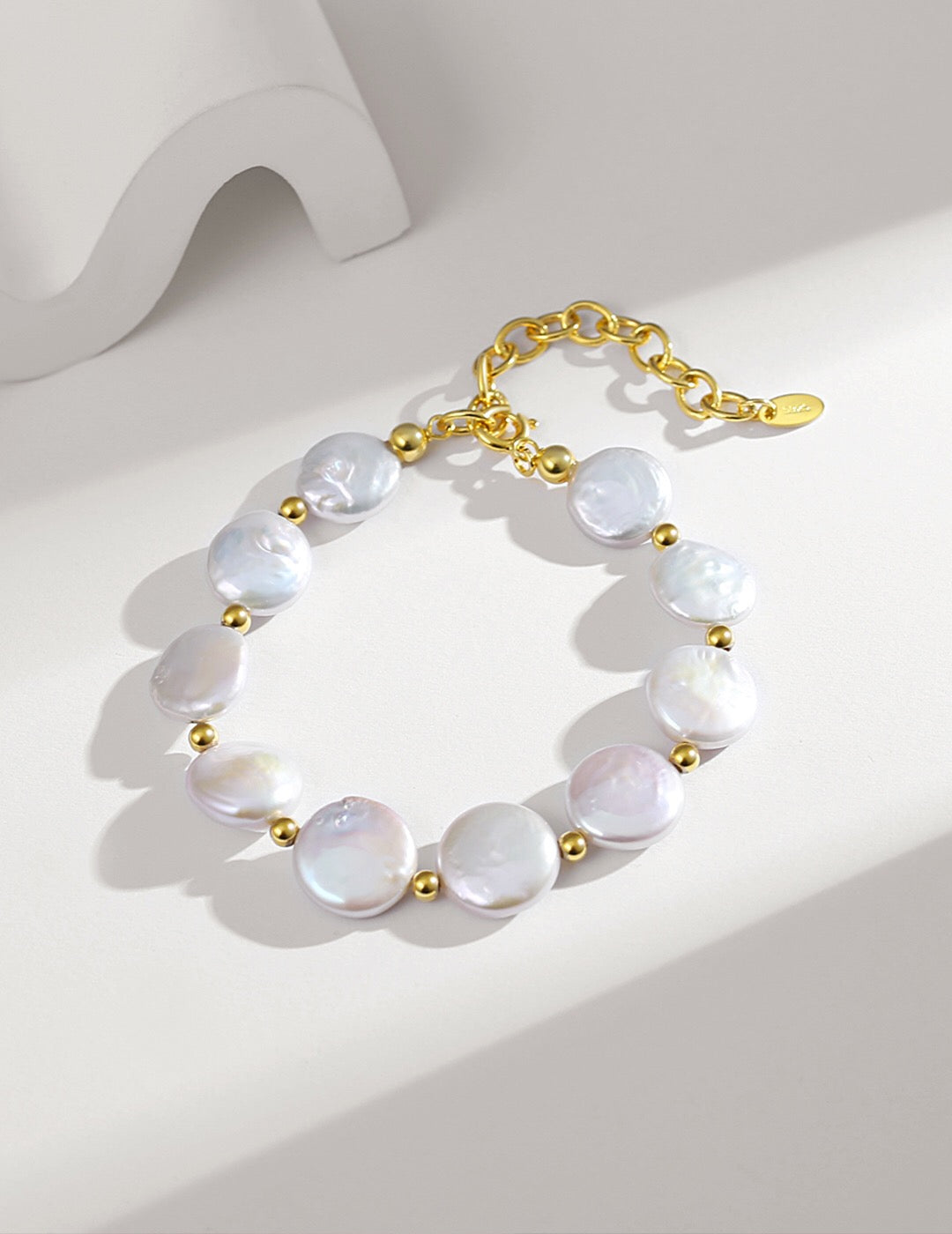 Flat Coin Pearl Bracelet featuring natural freshwater pearls and gold vermeil, elegantly displayed on a soft surface.