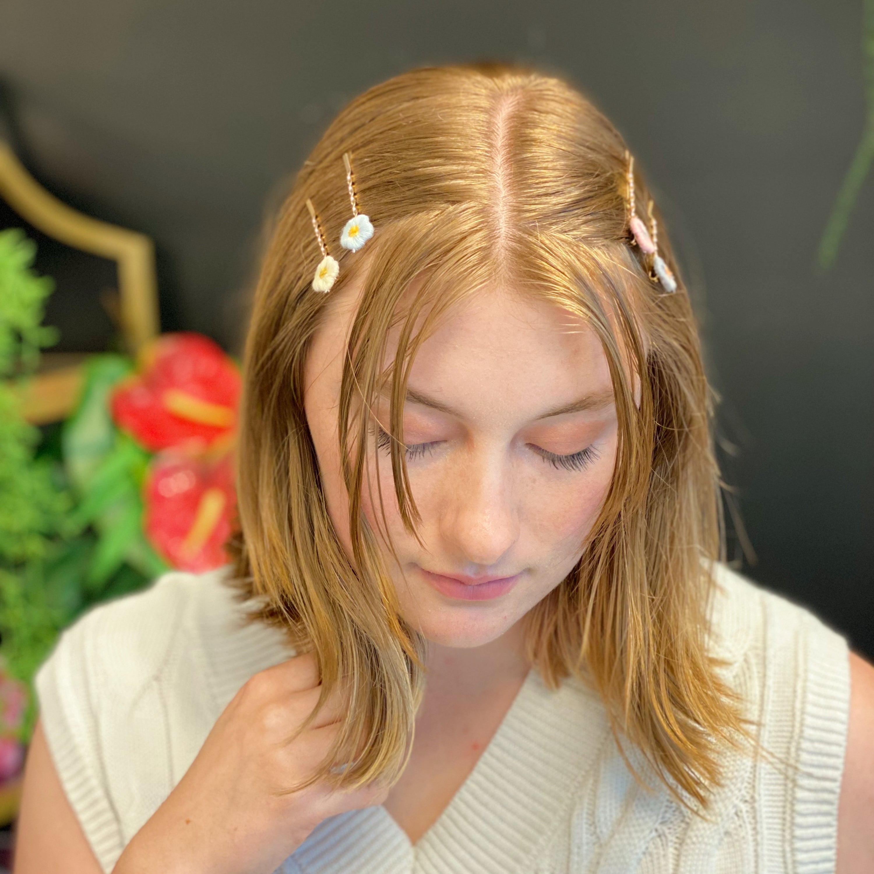 A set of six colorful bobby pins featuring adorable yarn flower designs, beautifully arranged in a clear cello bag.