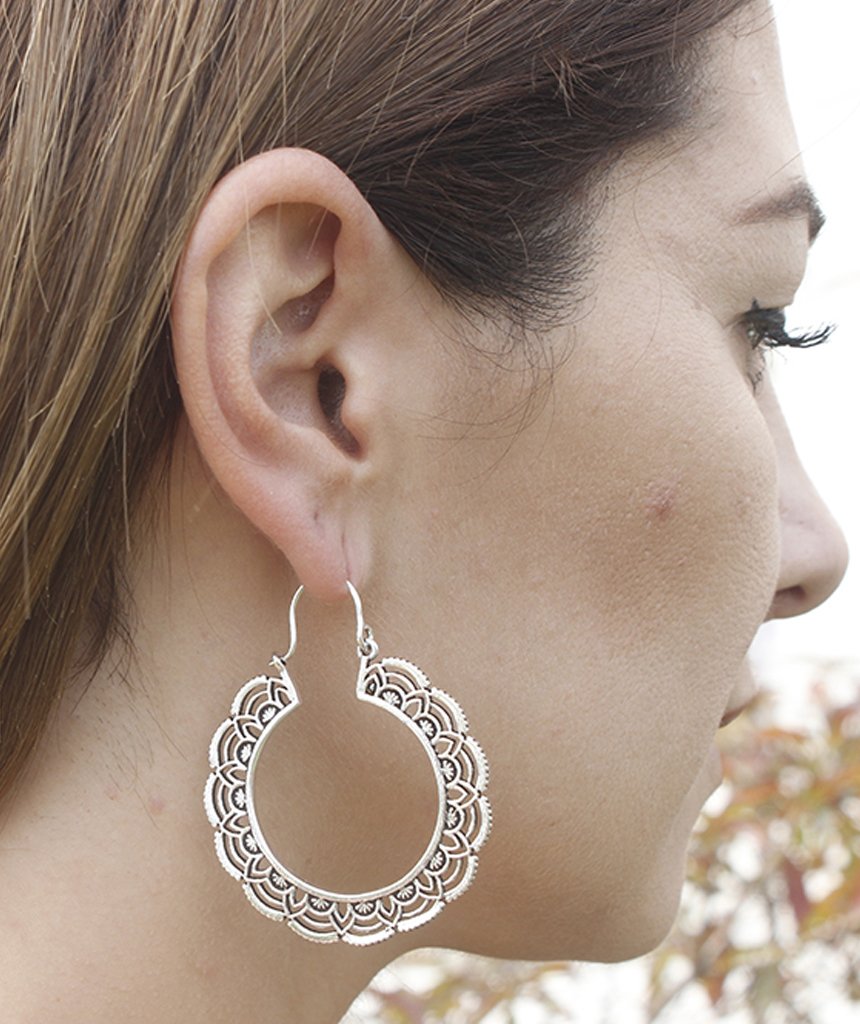 A pair of elegant floral hoop earrings featuring intricate etched designs, crafted from brass and silver-plated brass.