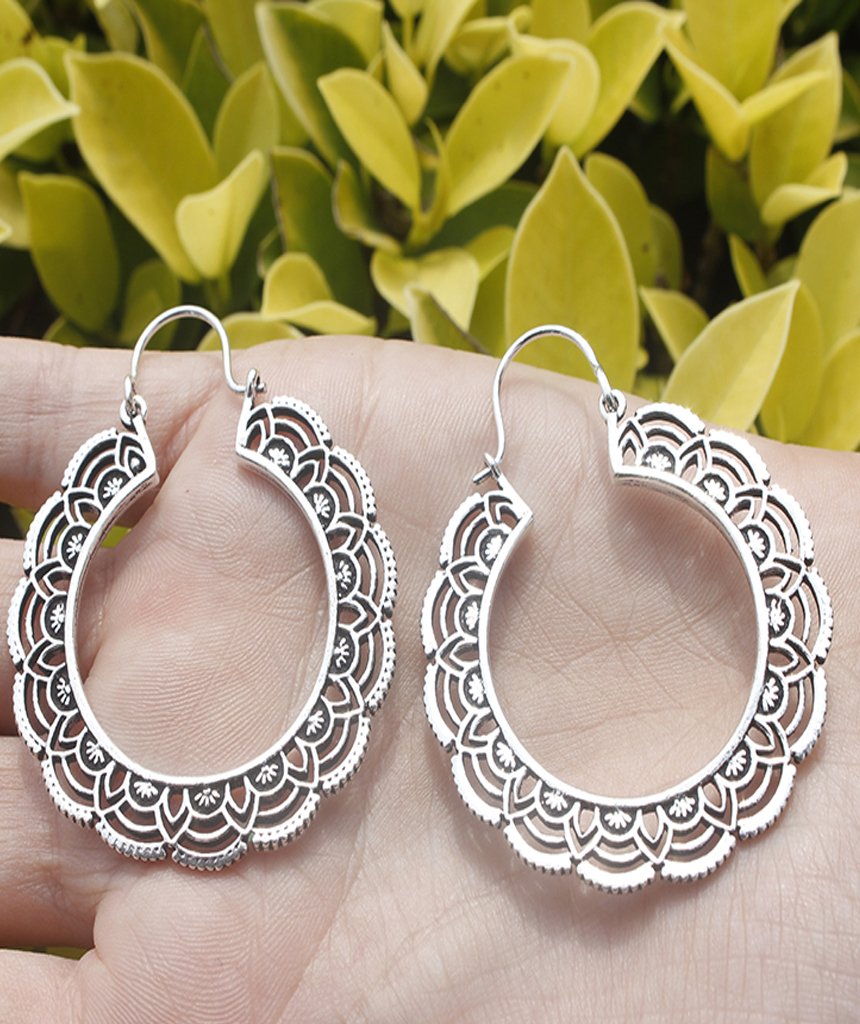 A pair of elegant floral hoop earrings featuring intricate etched designs, crafted from brass and silver-plated brass.