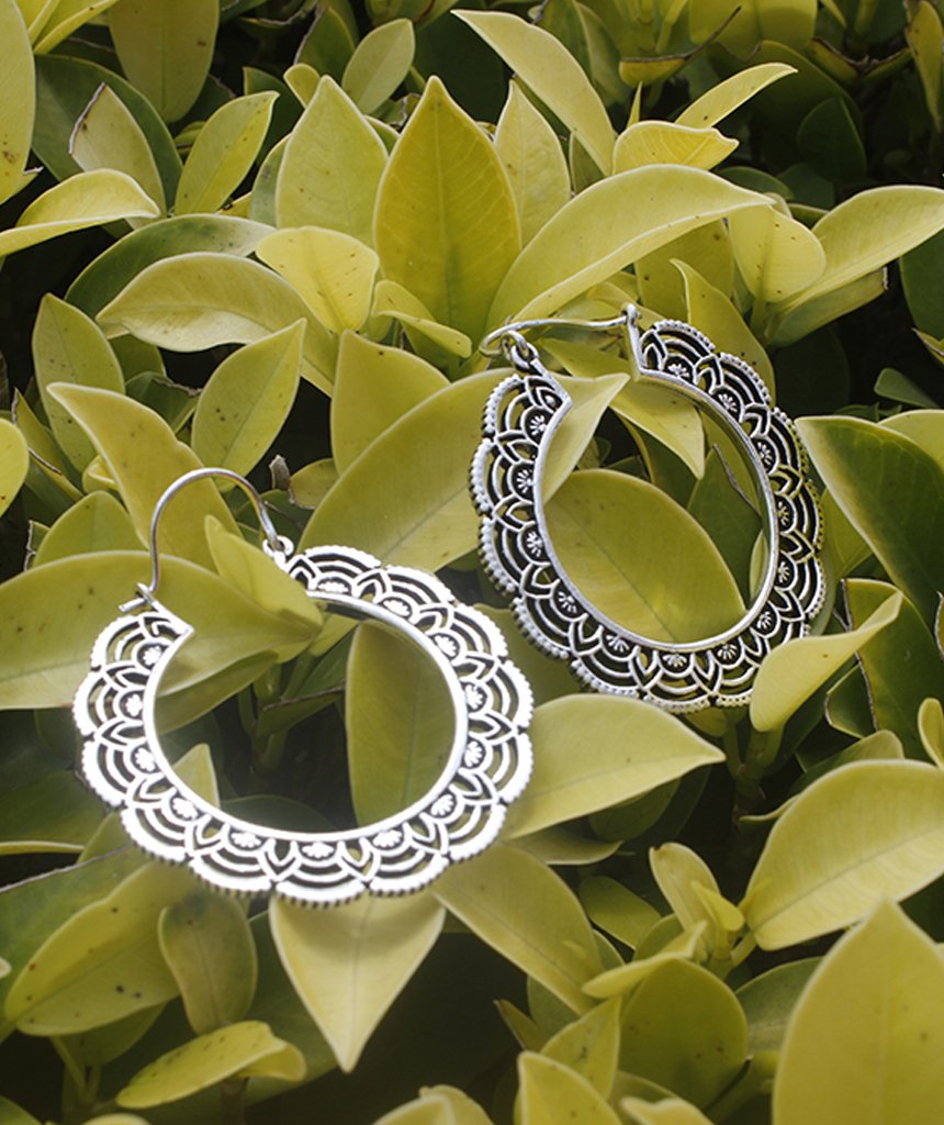 A pair of elegant floral hoop earrings featuring intricate etched designs, crafted from brass and silver-plated brass.