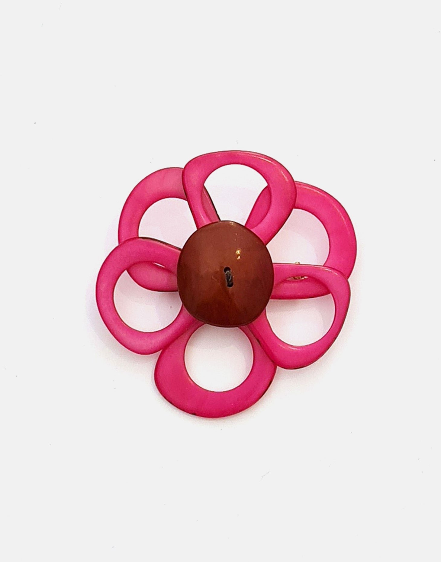 A delicate flower brooch designed as a daisy, made from slices of tagua, showcasing natural variations in color and texture.