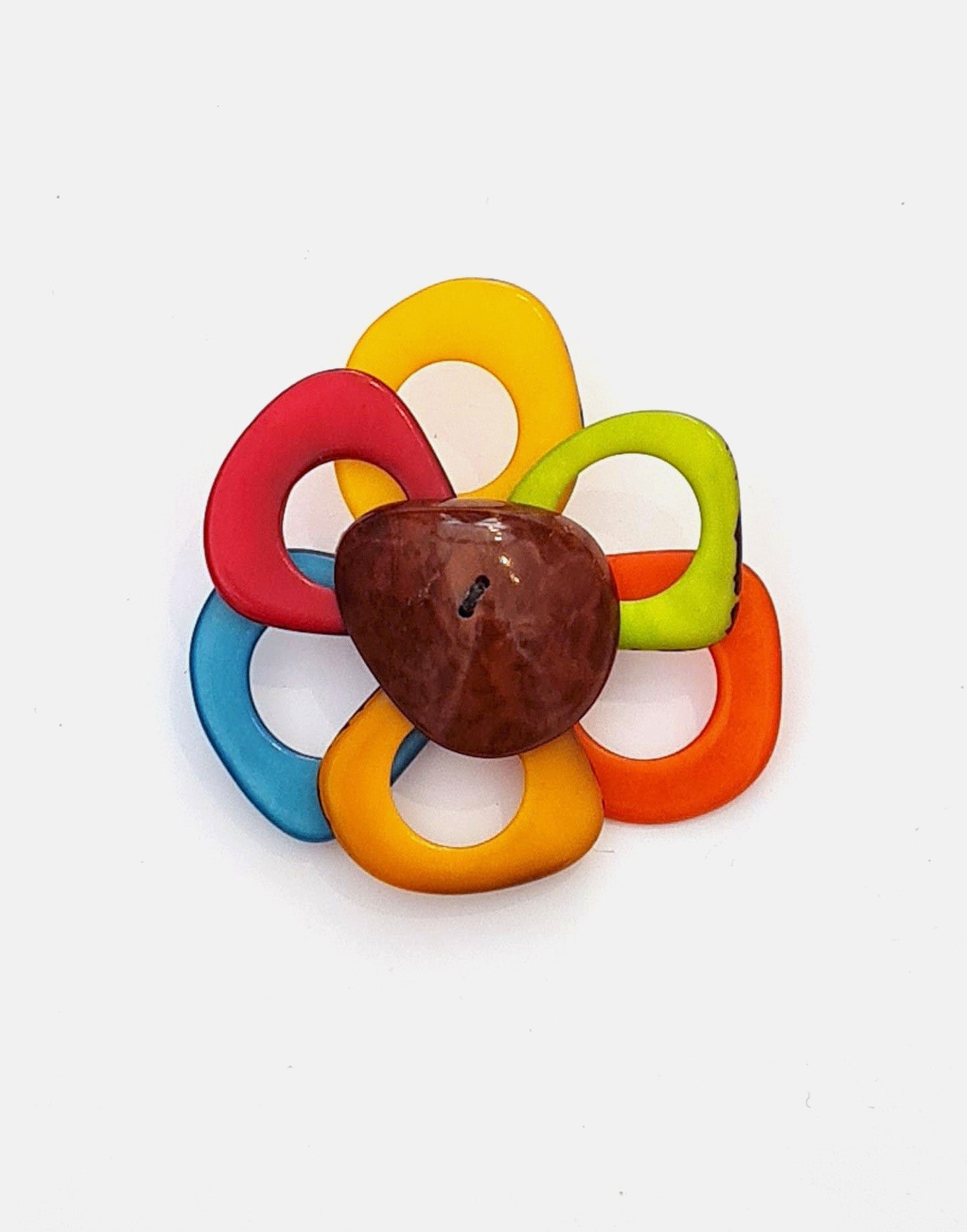 A delicate flower brooch designed as a daisy, made from slices of tagua, showcasing natural variations in color and texture.