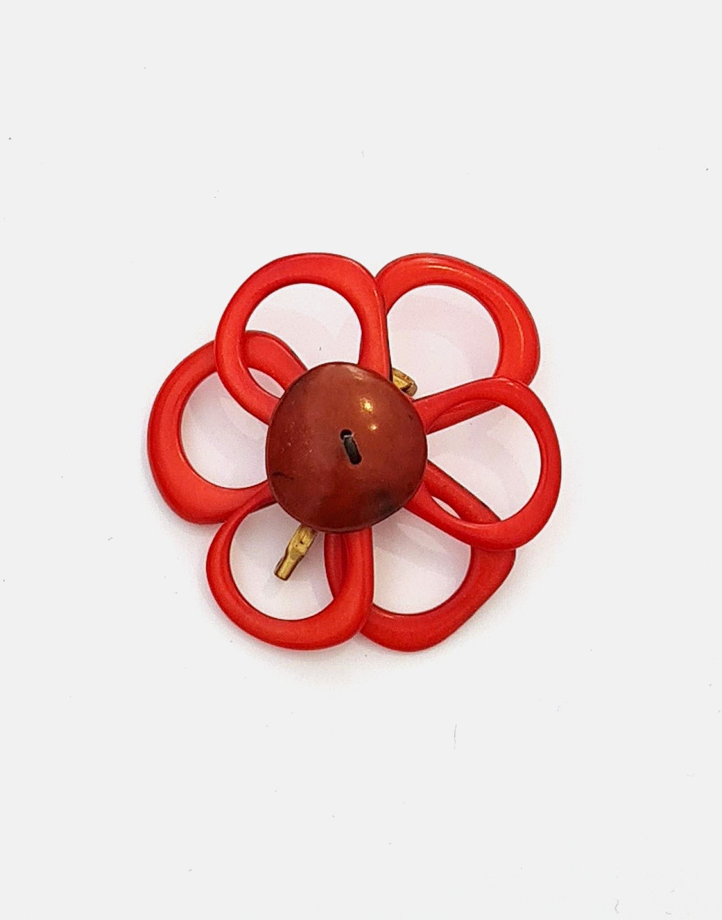 A delicate flower brooch designed as a daisy, made from slices of tagua, showcasing natural variations in color and texture.