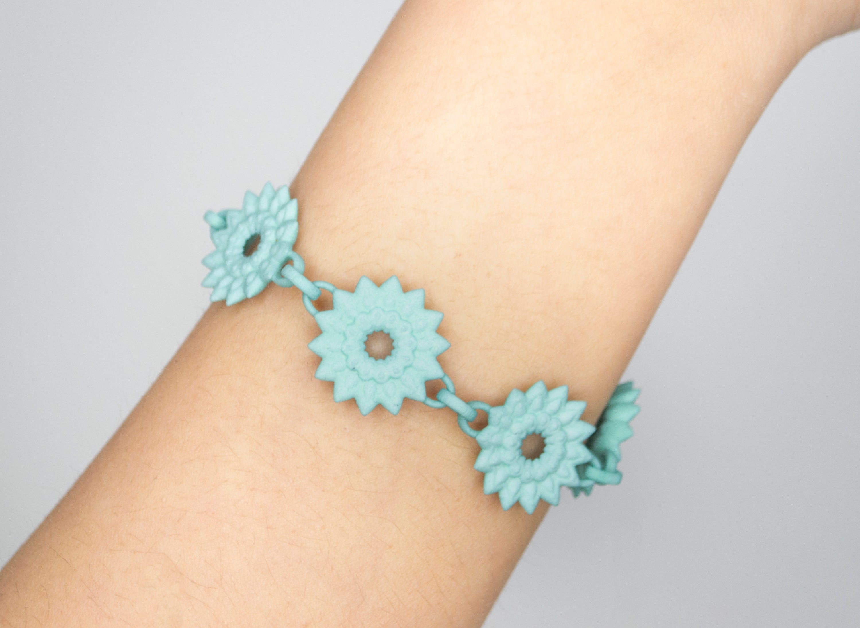 A vibrant Flower Chain Bracelet featuring delicate dahlia flowers, crafted from lightweight nylon material with a toggle clasp.