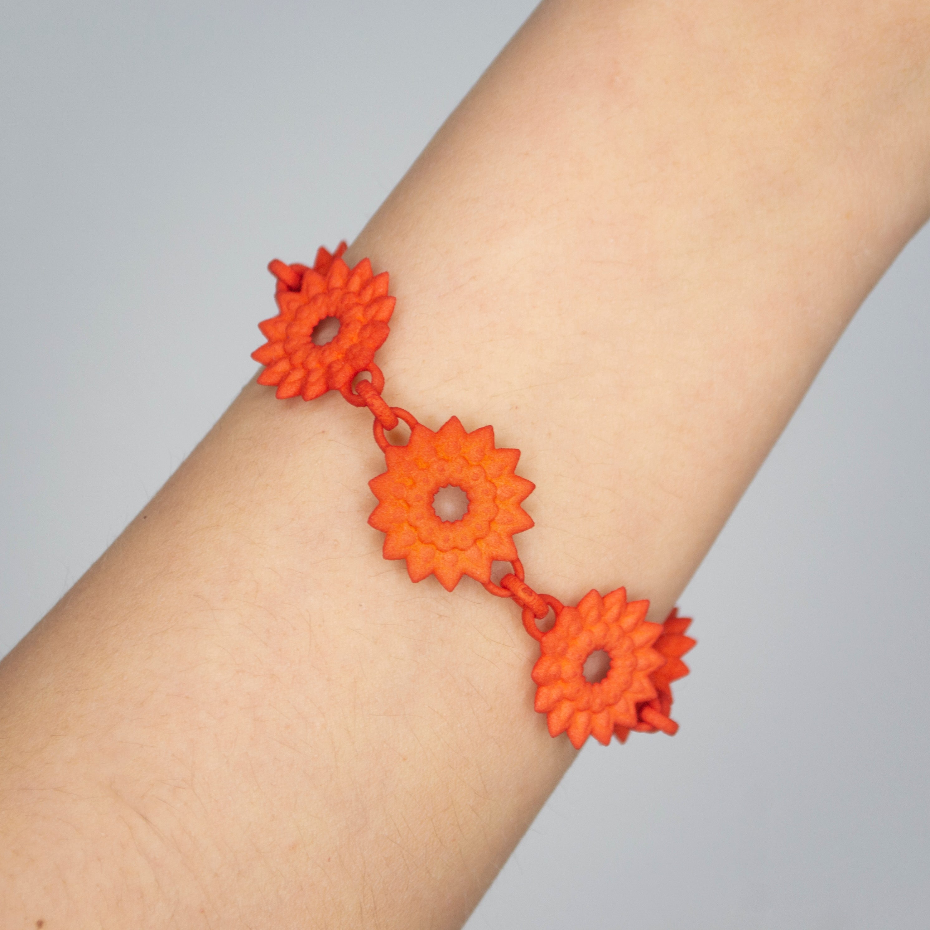 A vibrant Flower Chain Bracelet featuring delicate dahlia flowers, crafted from lightweight nylon material with a toggle clasp.