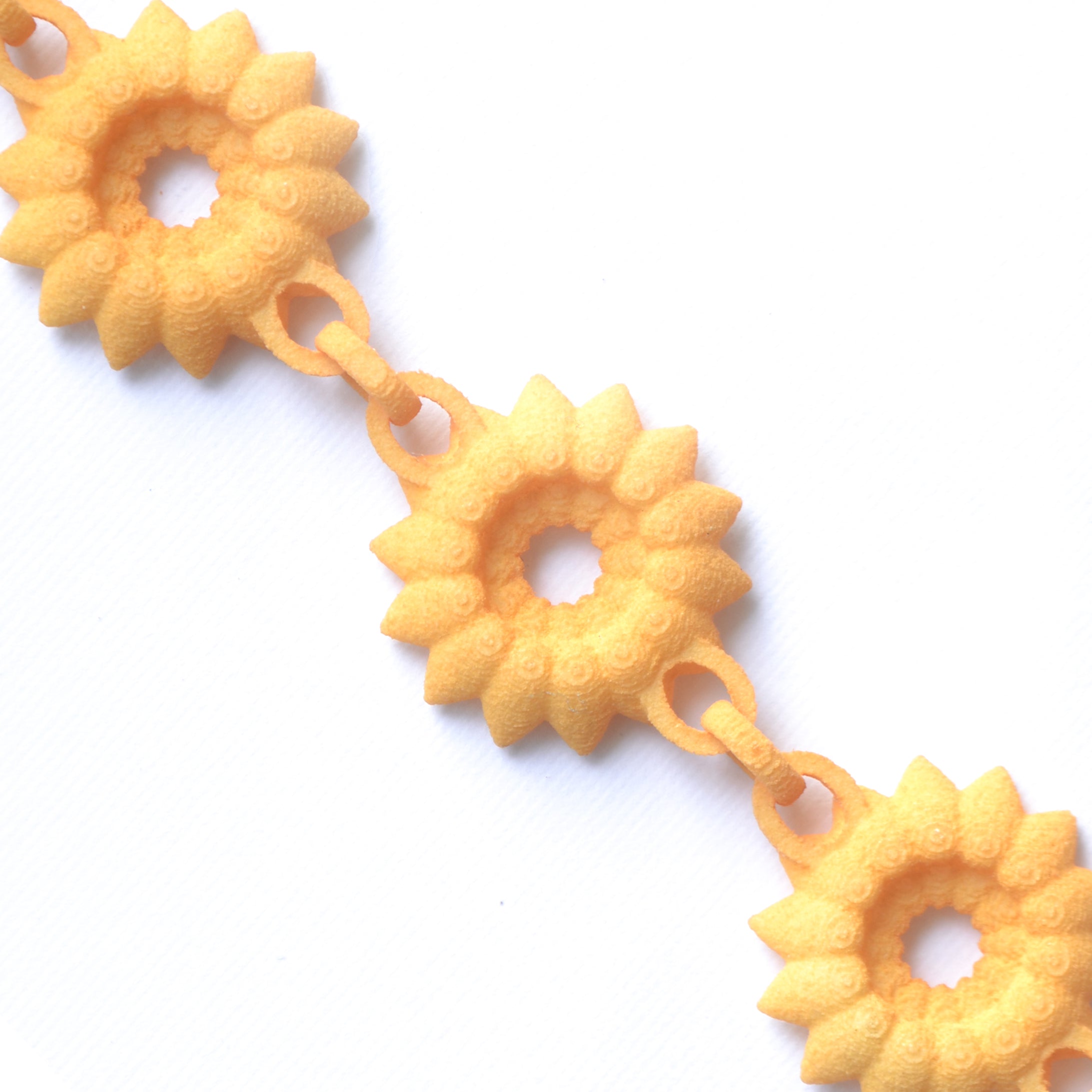 A vibrant Flower Chain Bracelet featuring delicate dahlia flowers, crafted from lightweight nylon material with a toggle clasp.