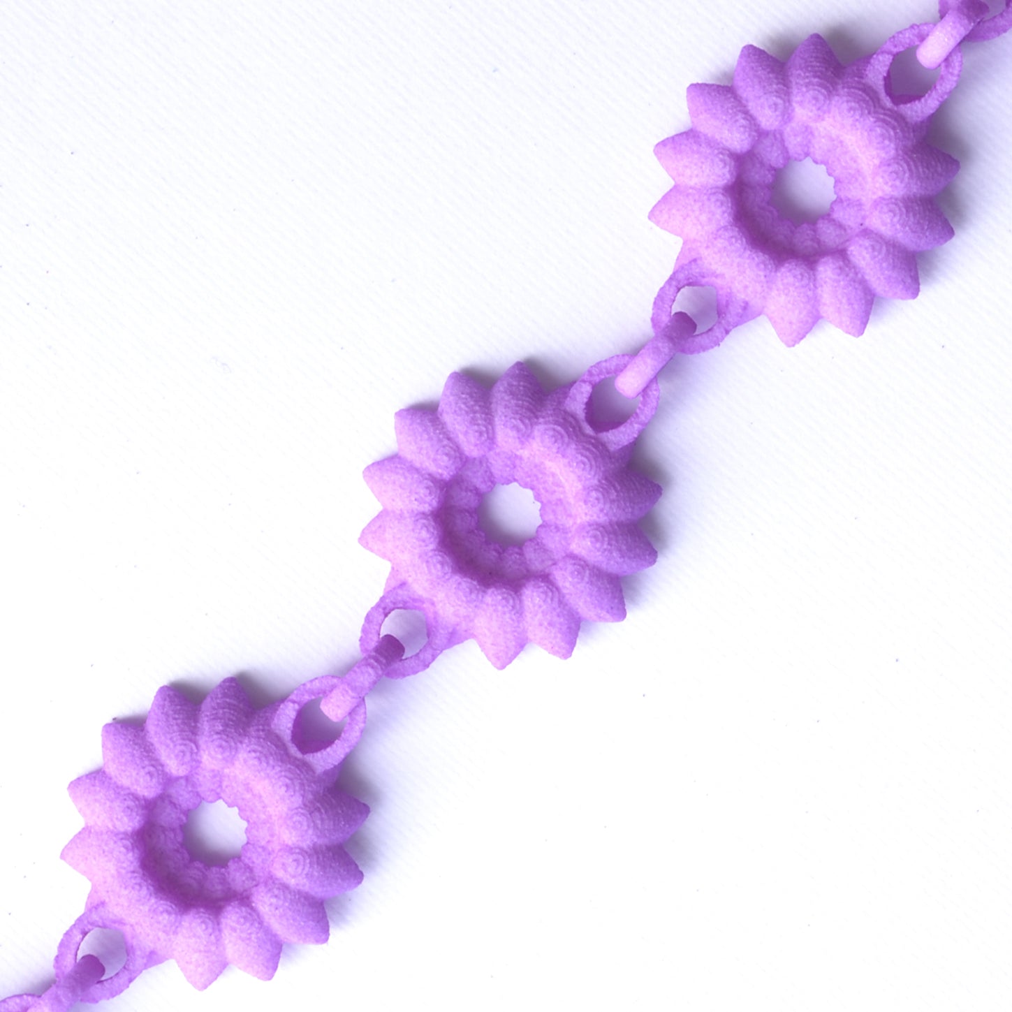 A vibrant Flower Chain Bracelet featuring delicate dahlia flowers, crafted from lightweight nylon material with a toggle clasp.