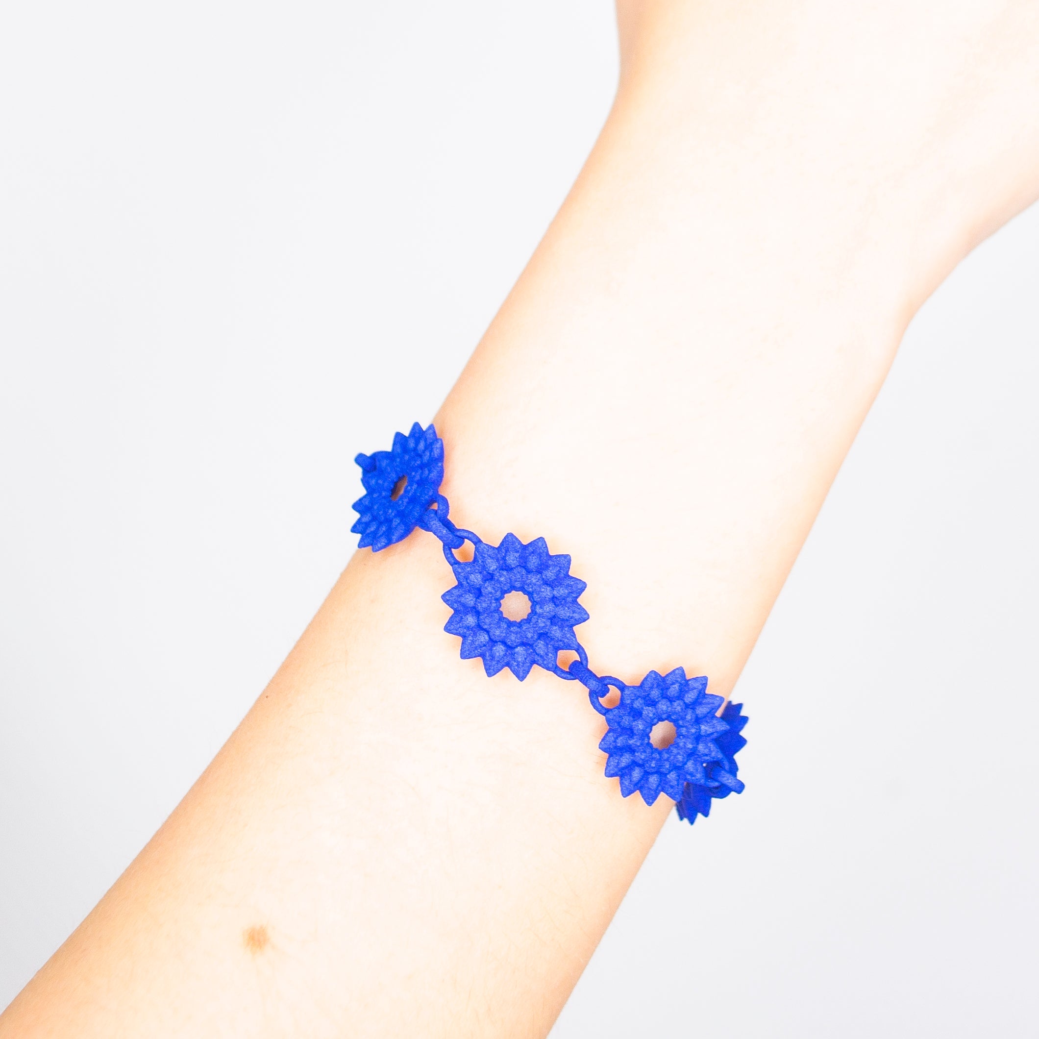 A vibrant Flower Chain Bracelet featuring delicate dahlia flowers, crafted from lightweight nylon material with a toggle clasp.