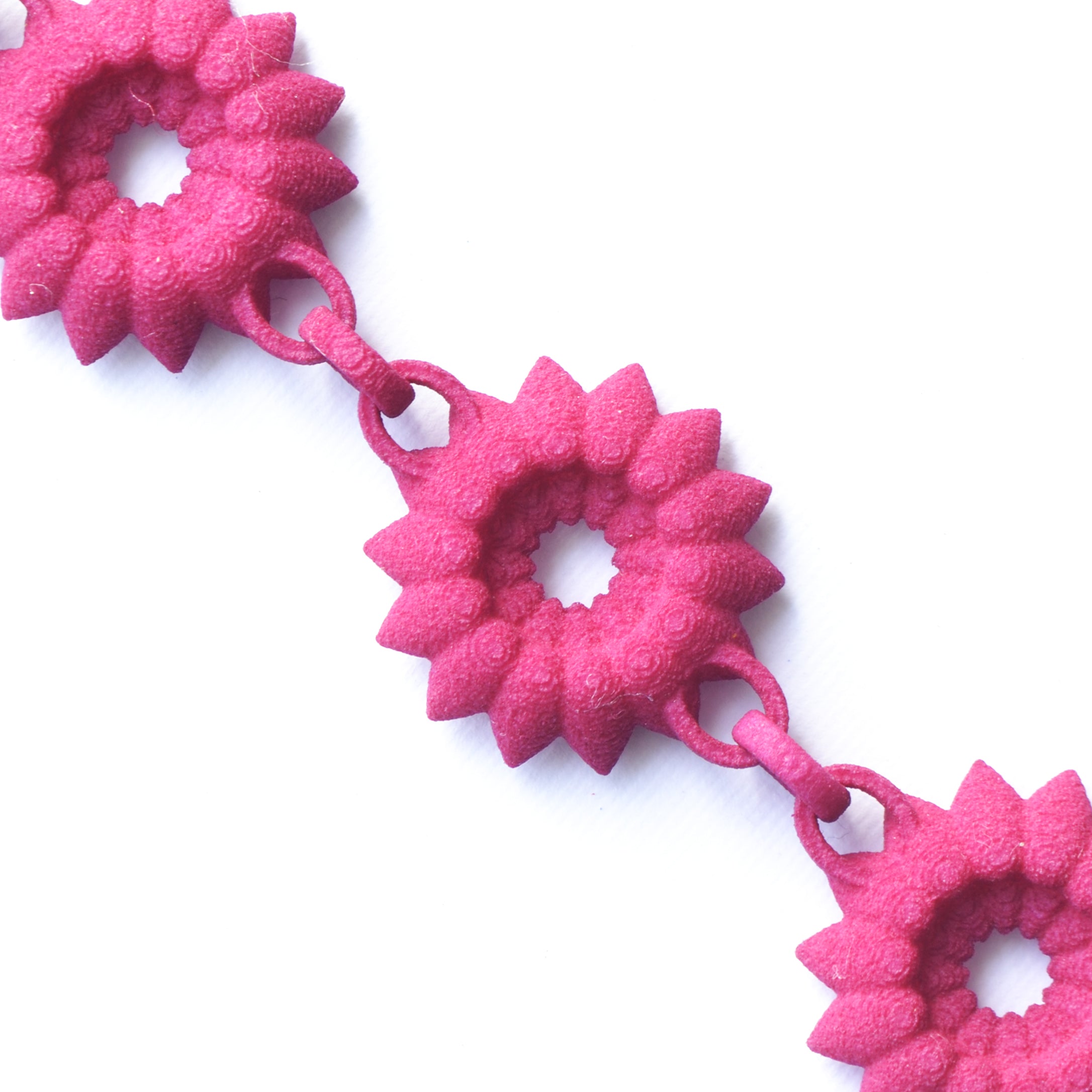 A vibrant Flower Chain Bracelet featuring delicate dahlia flowers, crafted from lightweight nylon material with a toggle clasp.