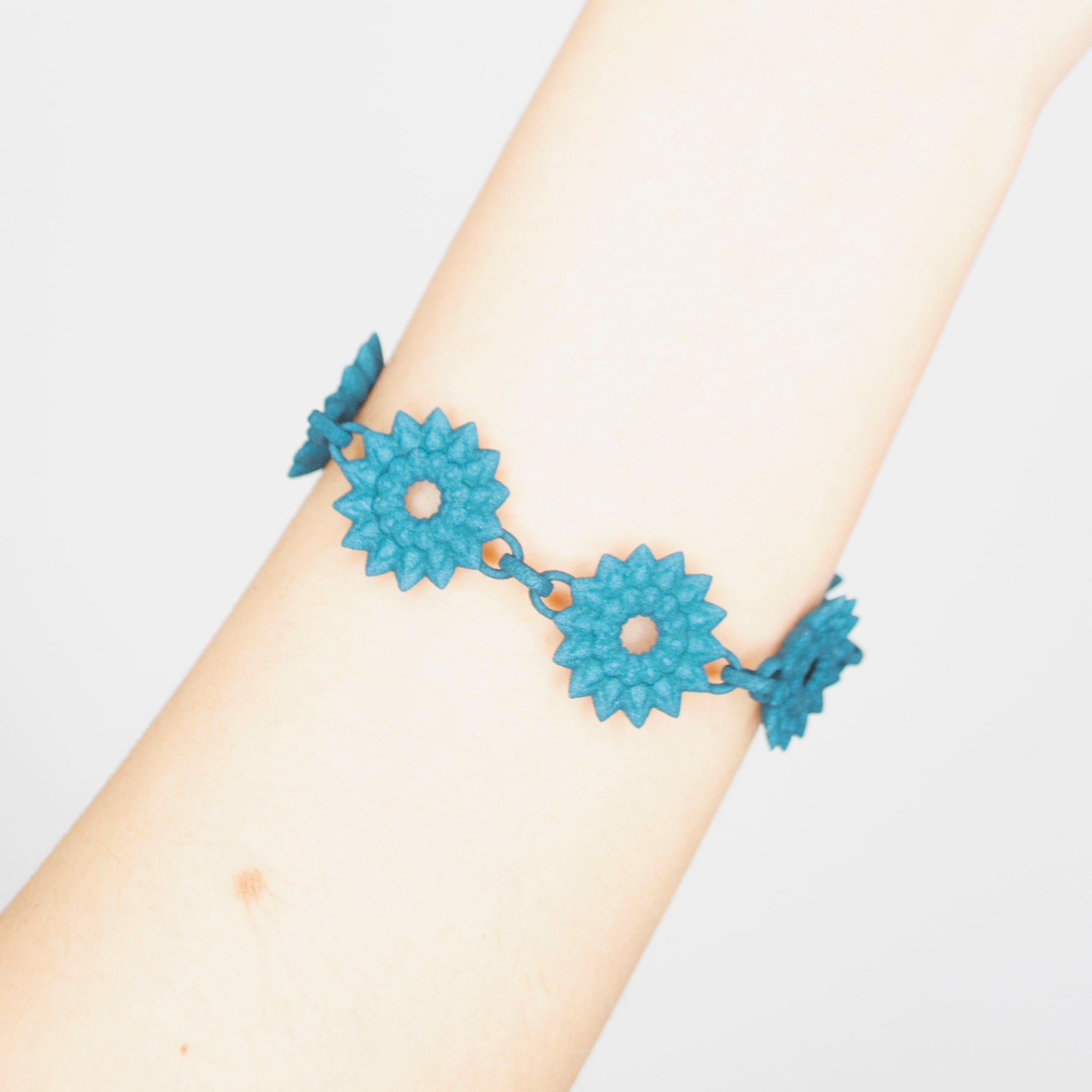 A vibrant Flower Chain Bracelet featuring delicate dahlia flowers, crafted from lightweight nylon material with a toggle clasp.