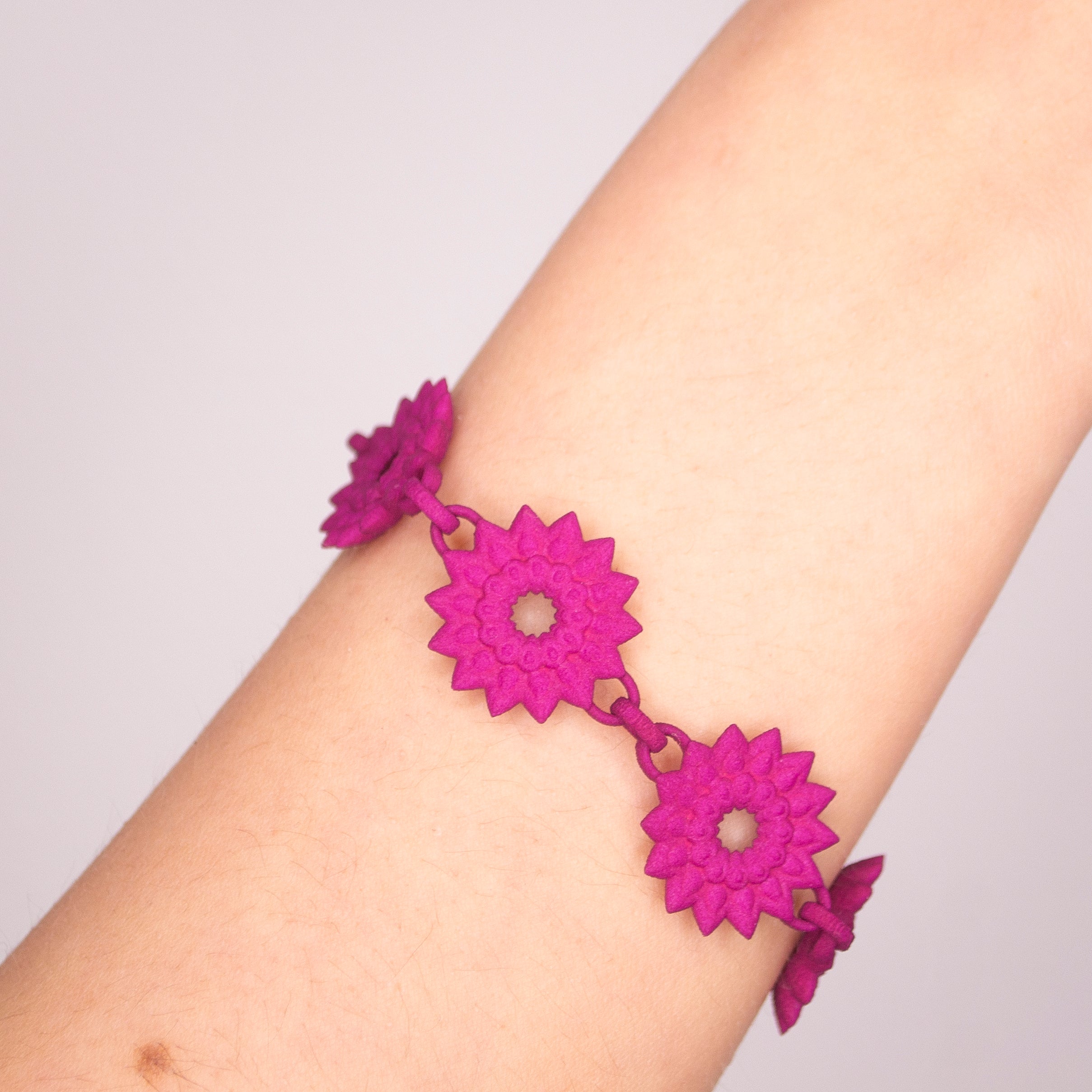 A vibrant Flower Chain Bracelet featuring delicate dahlia flowers, crafted from lightweight nylon material with a toggle clasp.