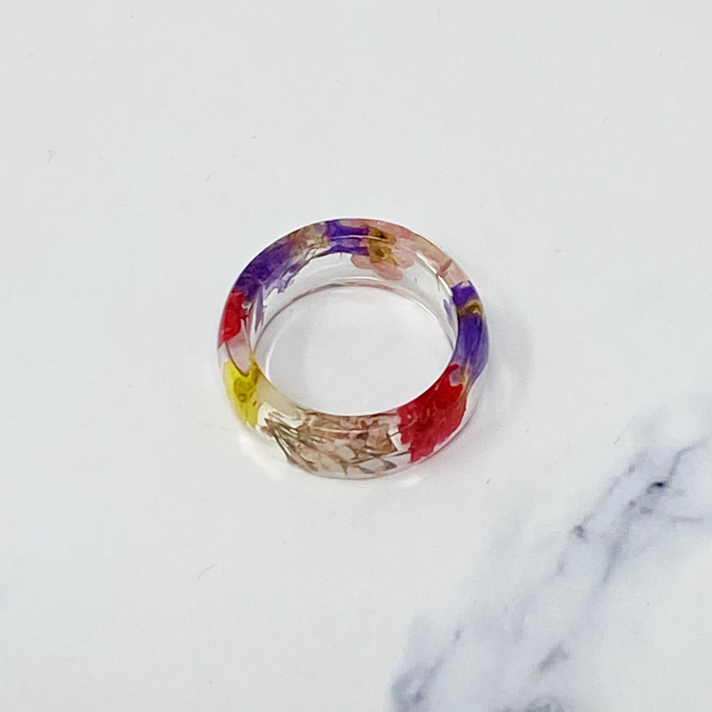 A chic Flower Field Acrylic Ring featuring preserved natural flowers encased in clear acrylic, size 7.