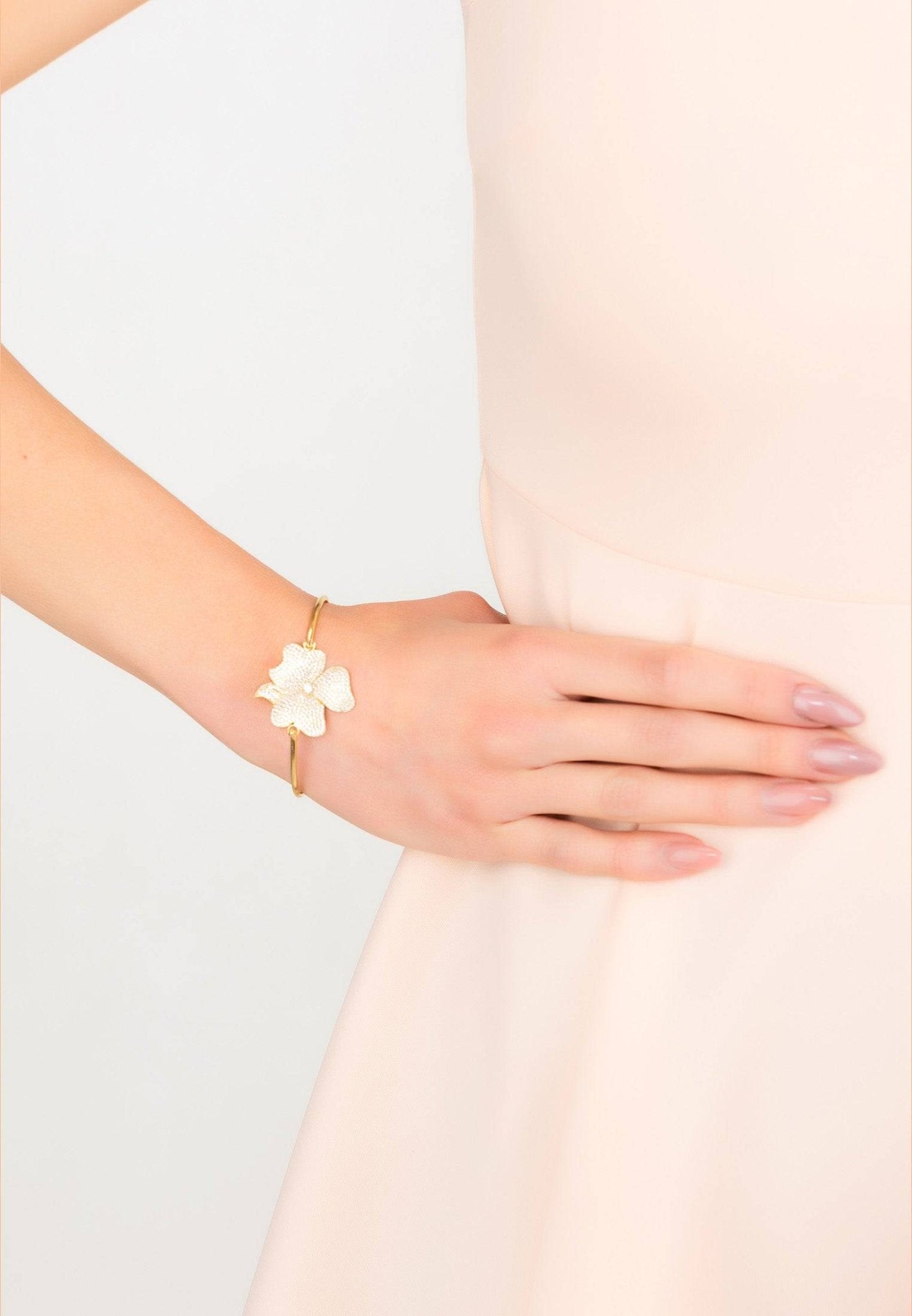 Elegant Flower Large Statement Cuff Bracelet in gold with cubic zirconia embellishments, showcasing a floral design on a metallic bangle.