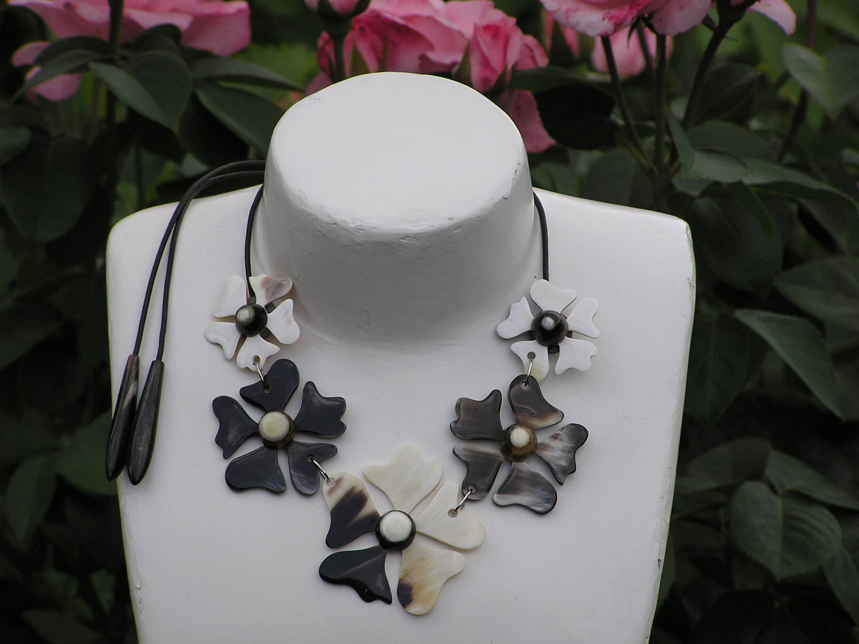 A beautifully crafted flower necklace for women made from natural buffalo horn, featuring intricate floral designs and a leather cord.