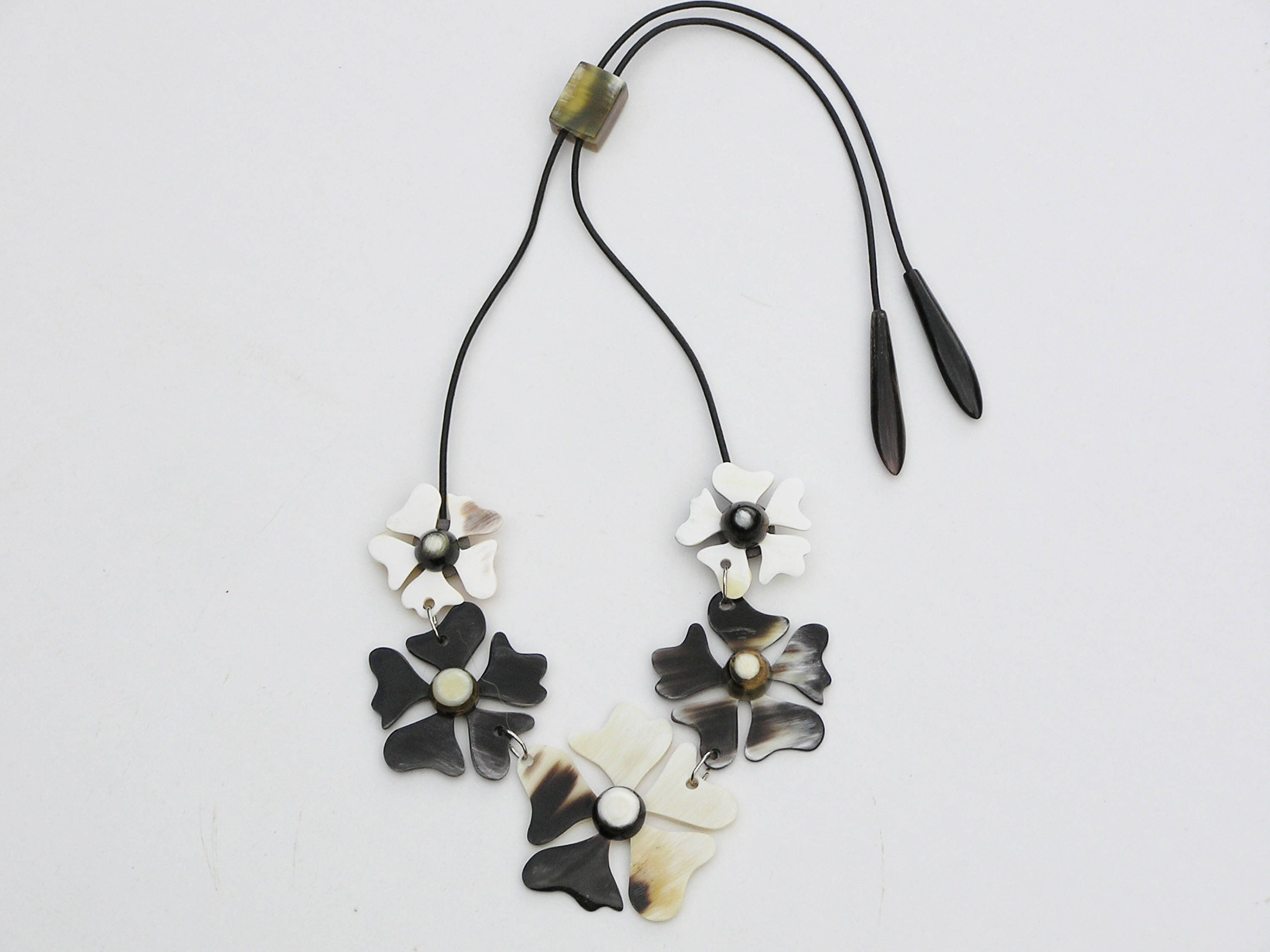 A beautifully crafted flower necklace for women made from natural buffalo horn, featuring intricate floral designs and a leather cord.