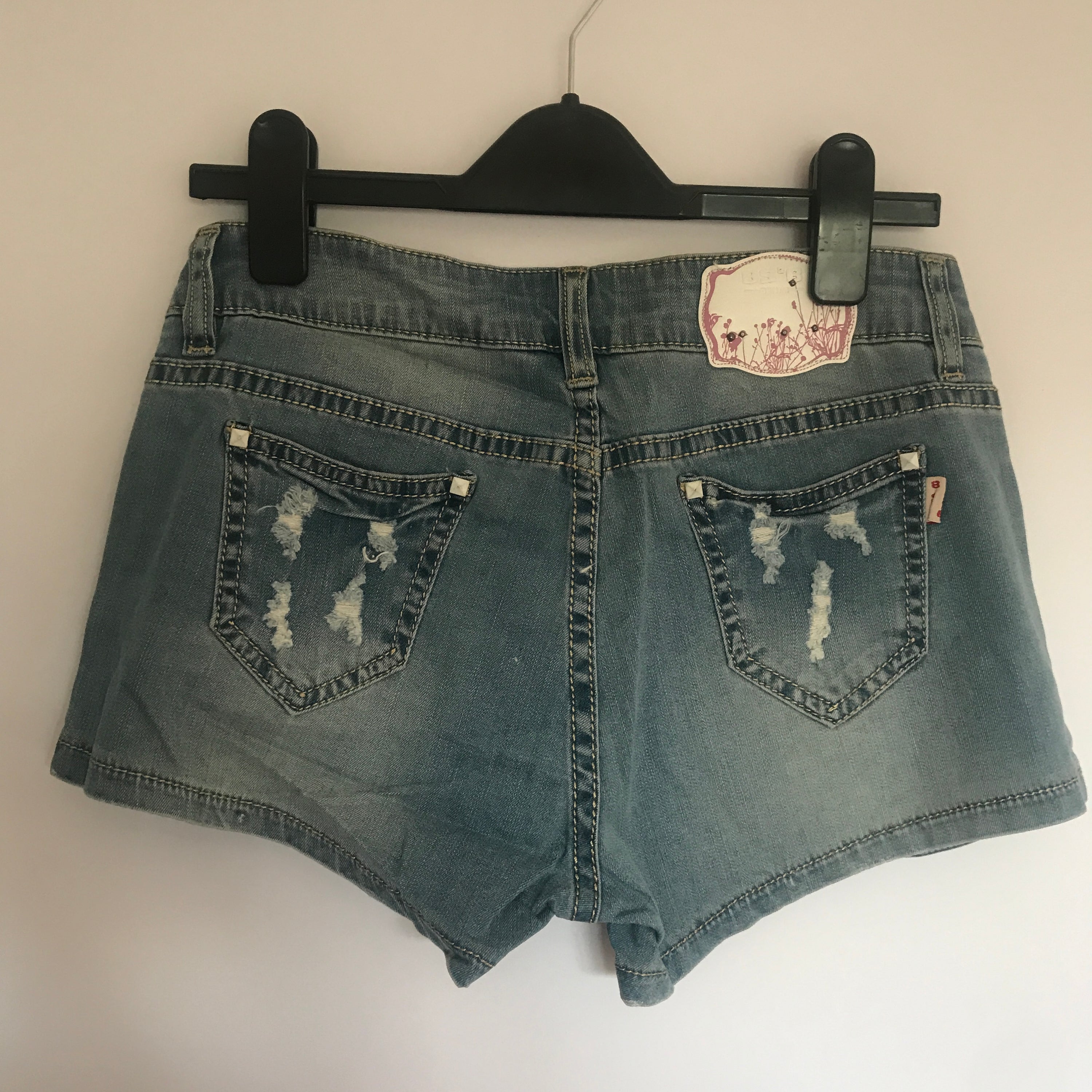 A pair of stylish denim shorts adorned with flower rhinestones, showcasing a trendy summer look.