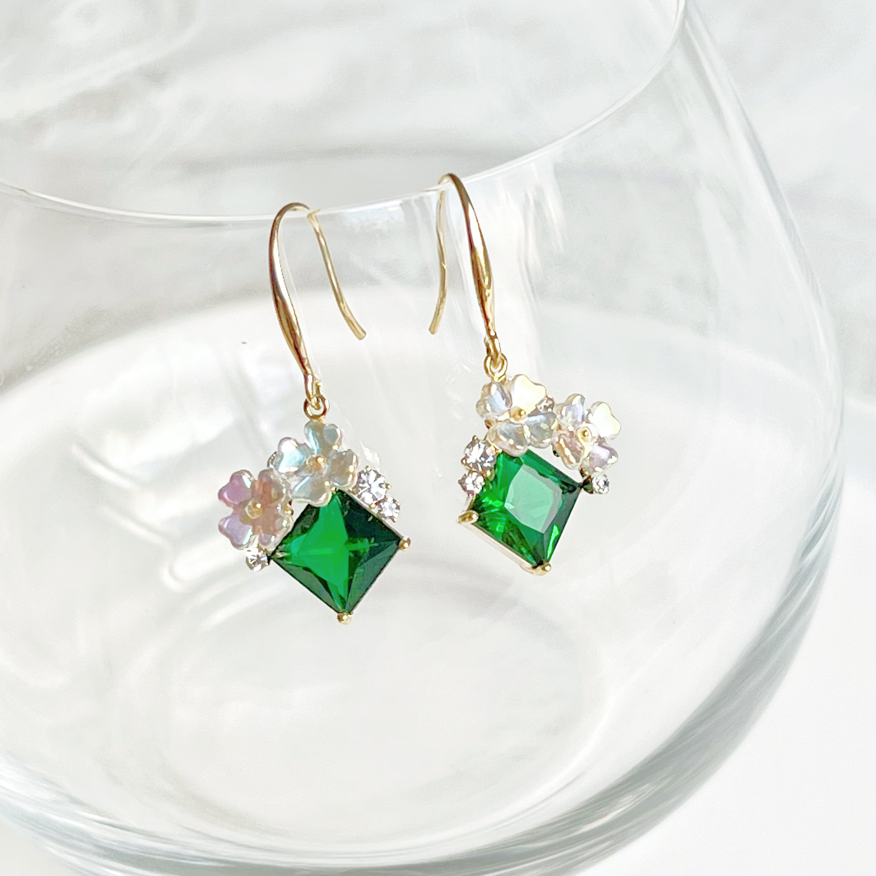 Elegant flower earrings featuring emerald green crystal drops, crafted from gold-plated bronze.