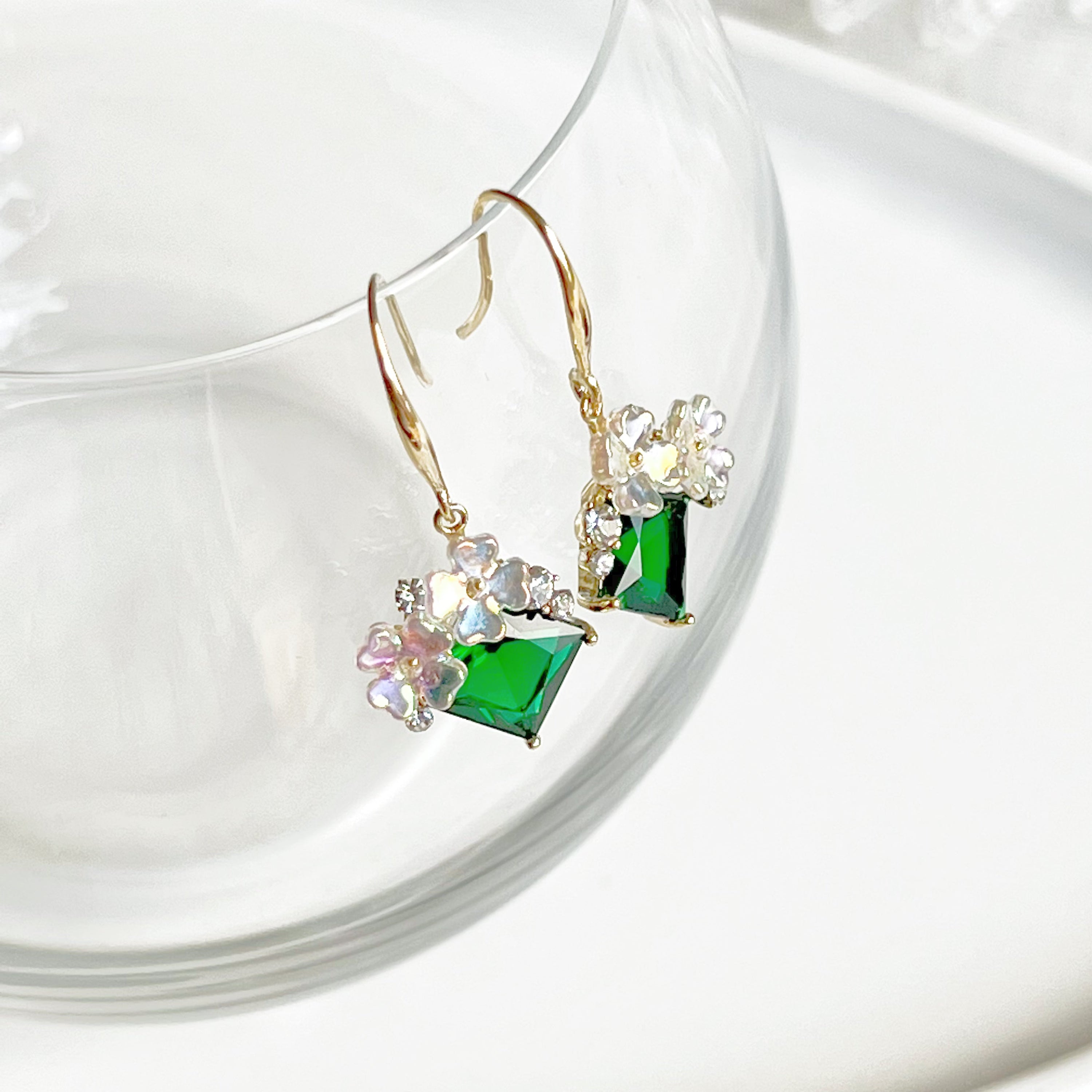 Elegant flower earrings featuring emerald green crystal drops, crafted from gold-plated bronze.