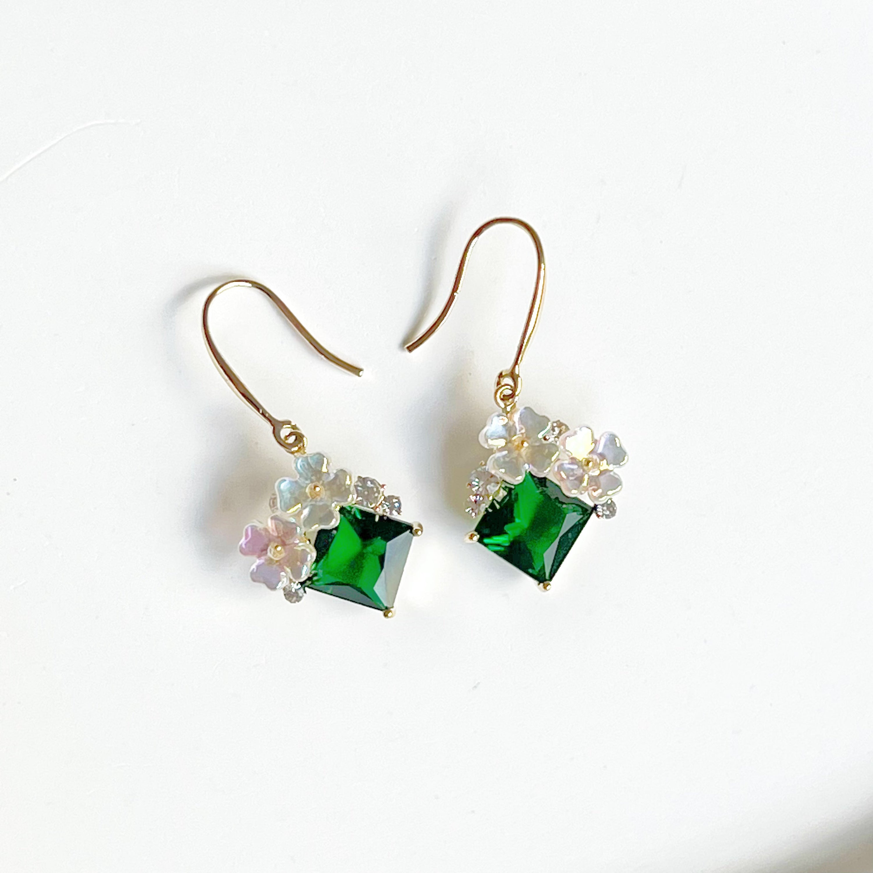 Elegant flower earrings featuring emerald green crystal drops, crafted from gold-plated bronze.