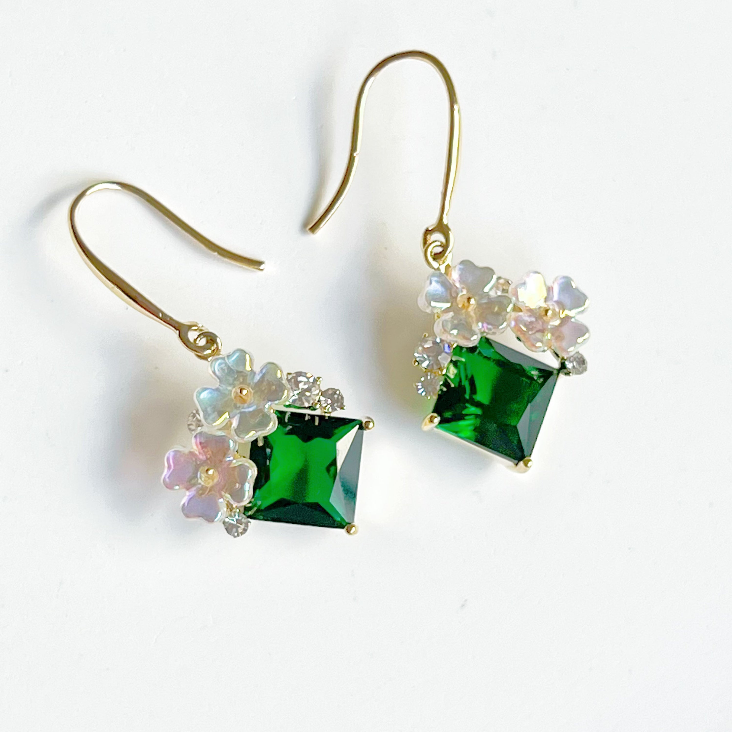 Elegant flower earrings featuring emerald green crystal drops, crafted from gold-plated bronze.