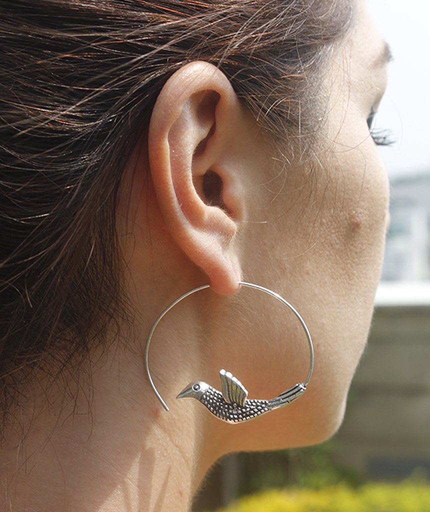 A pair of stunning Flying Bird Statement Earrings in brass with intricate hand-carved designs, showcasing a shiny finish, perfect for festivals.