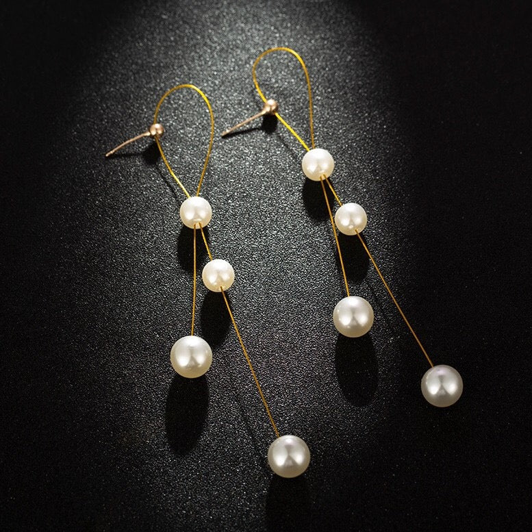 Elegant Folded Long Tassel Earrings adorned with pearls, showcasing a stylish design perfect for any occasion.