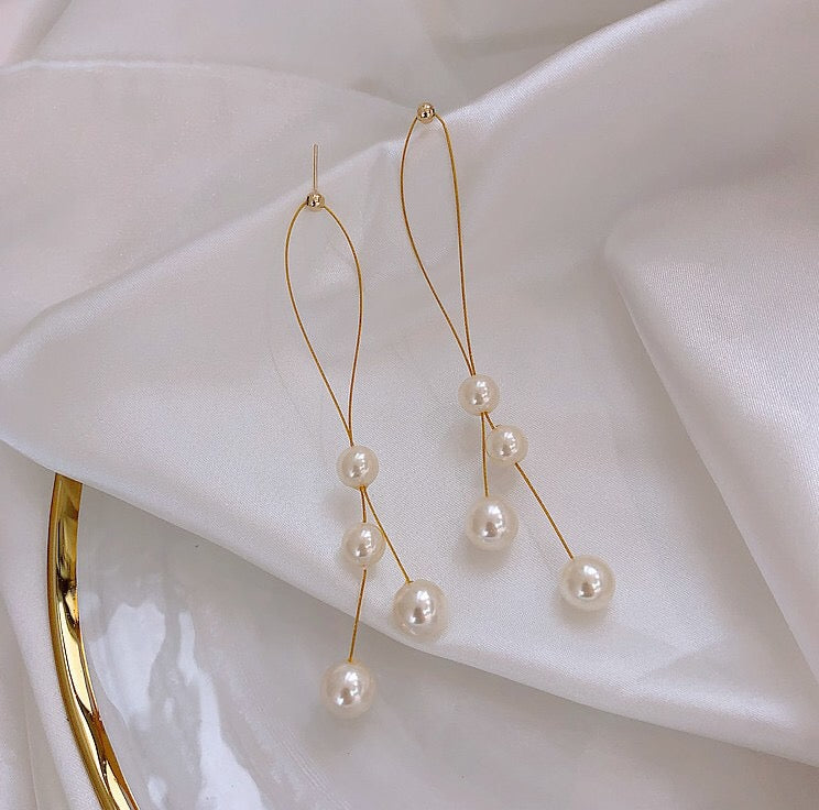 Elegant Folded Long Tassel Earrings adorned with pearls, showcasing a stylish design perfect for any occasion.