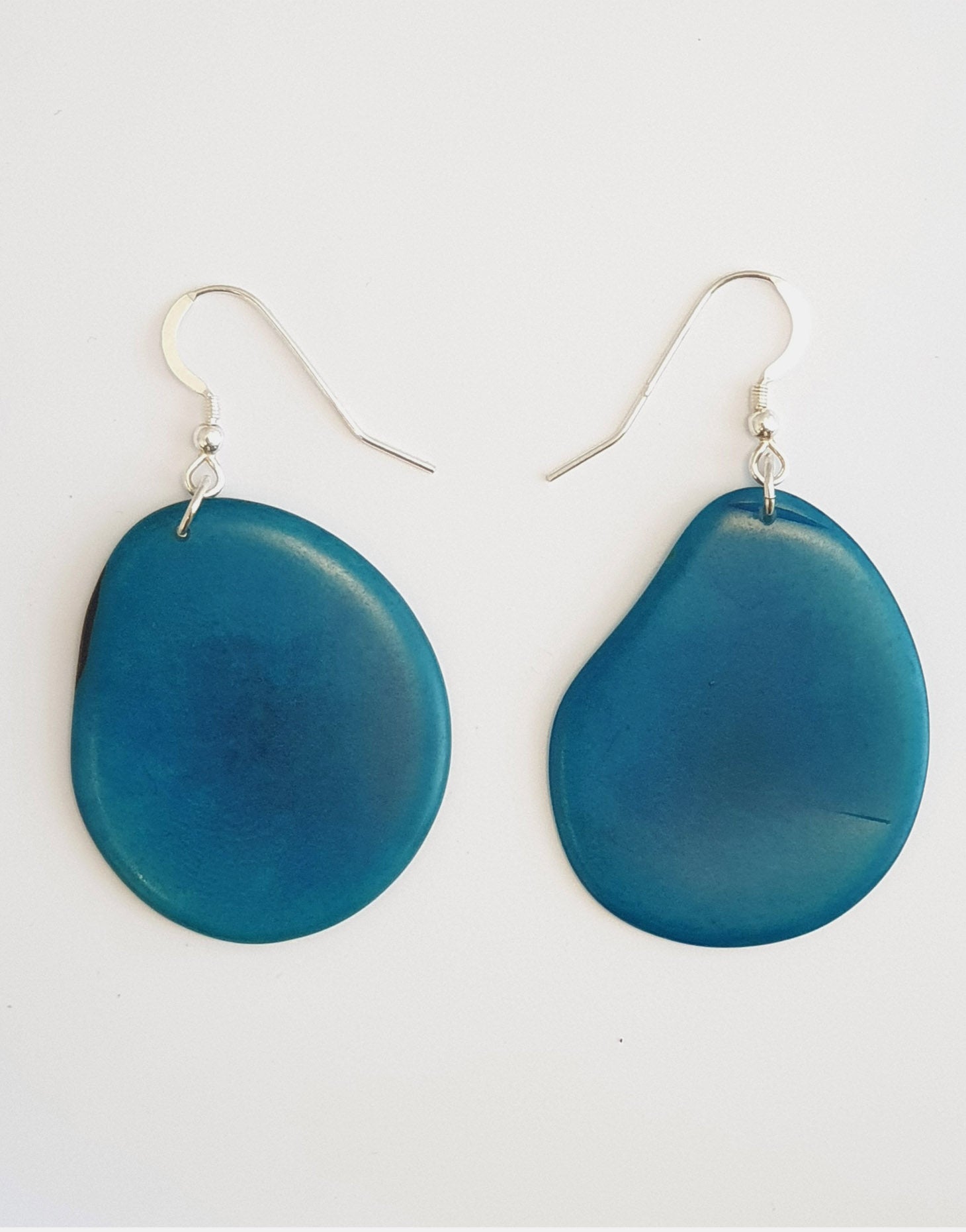 A pair of Folha Tagua Nut Earrings made from vegetable ivory with sterling silver hooks, showcasing unique natural textures and colors.