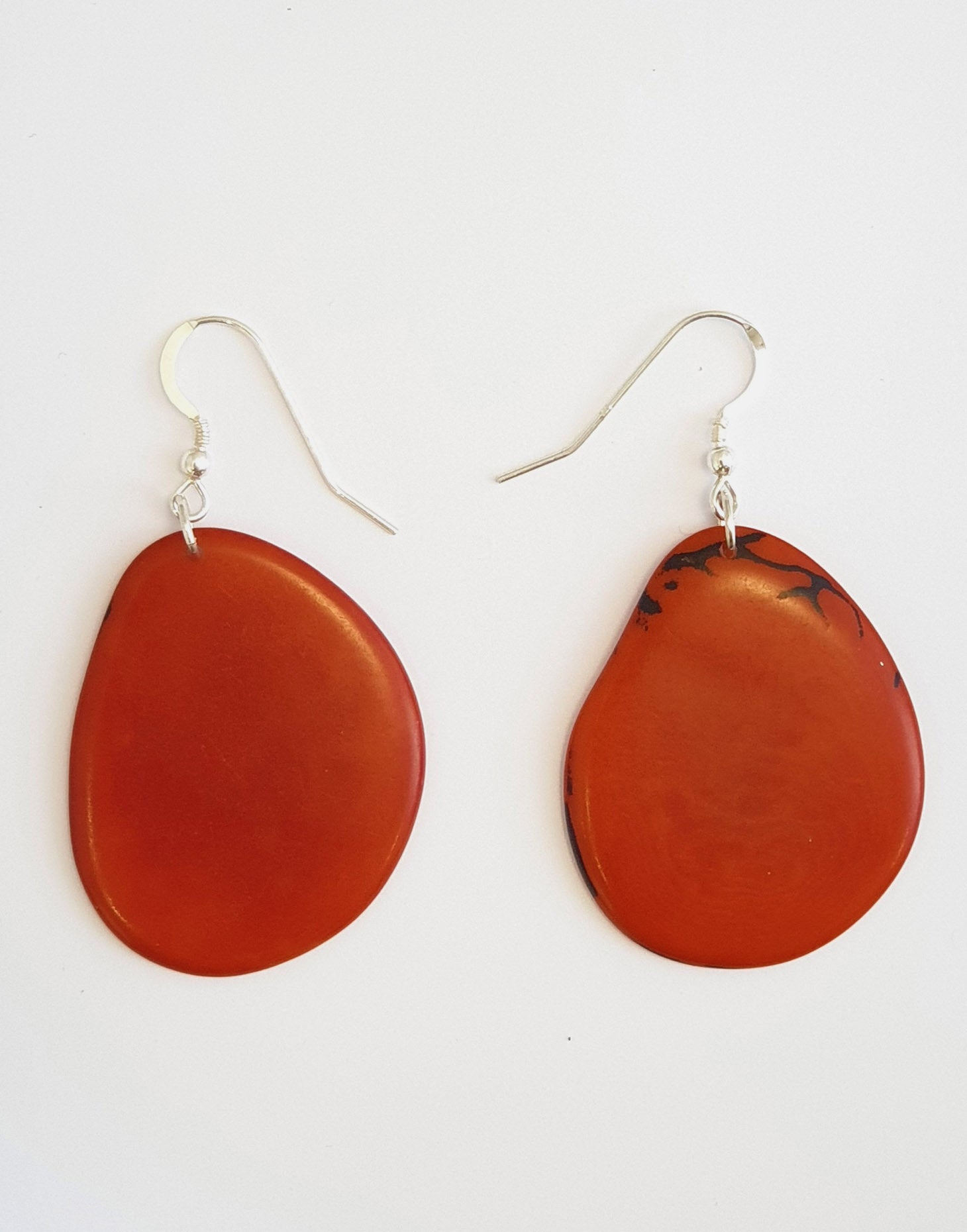 A pair of Folha Tagua Nut Earrings made from vegetable ivory with sterling silver hooks, showcasing unique natural textures and colors.