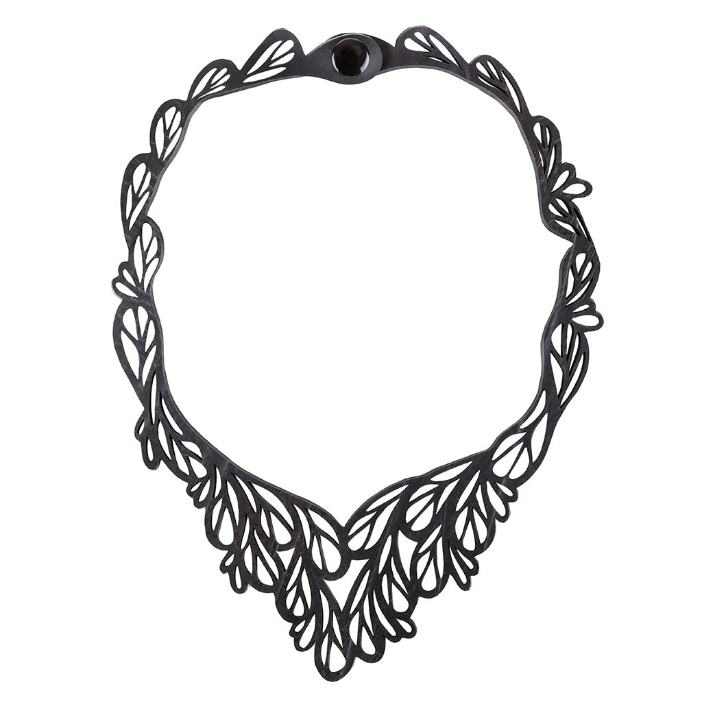 Fountain Rubber Necklace made from reclaimed inner tubes, featuring a v-shaped design and a durable cord with a plastic button closure.