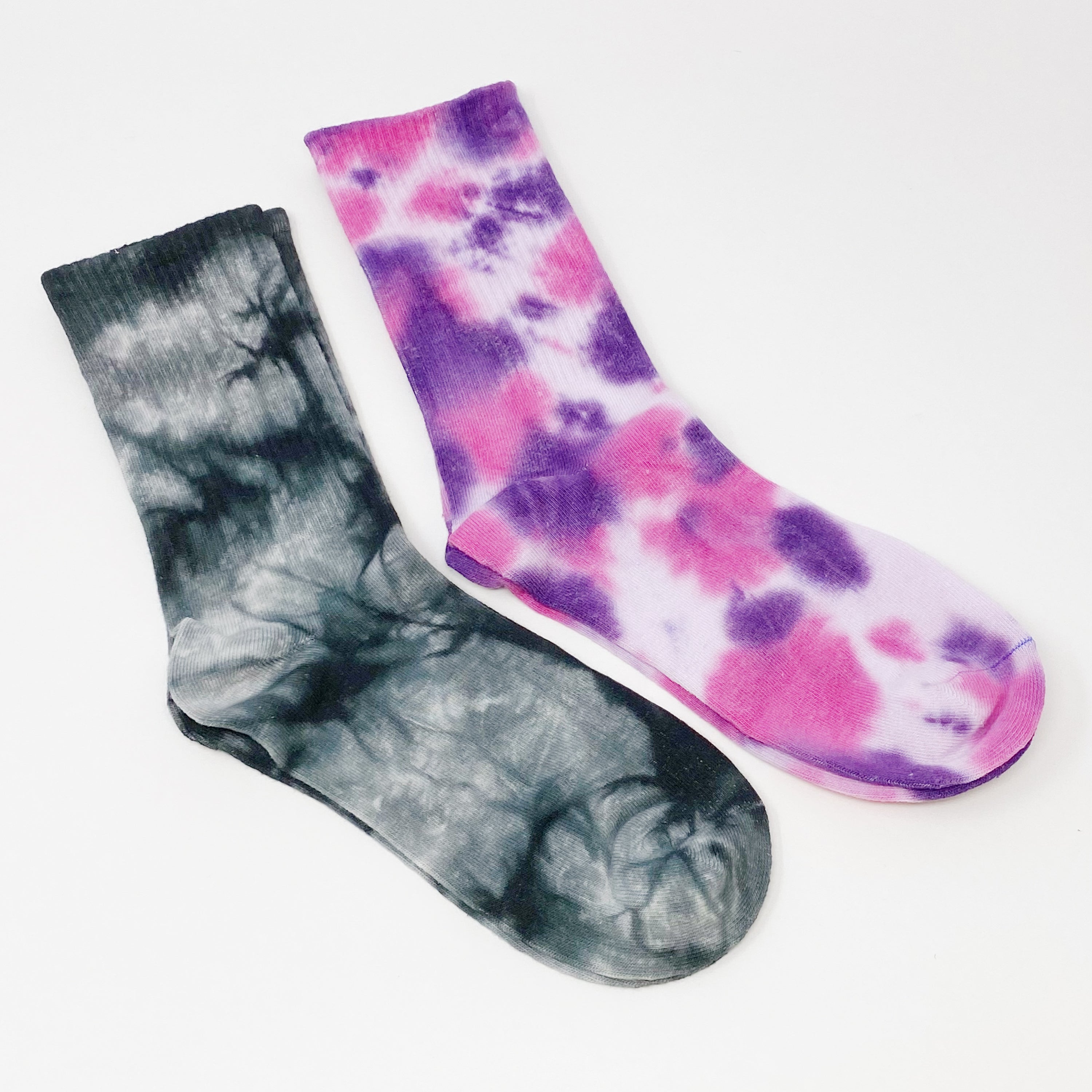 A set of two pairs of colorful tie dye socks, showcasing vibrant patterns and a comfortable fit, packaged in a clear cello bag.