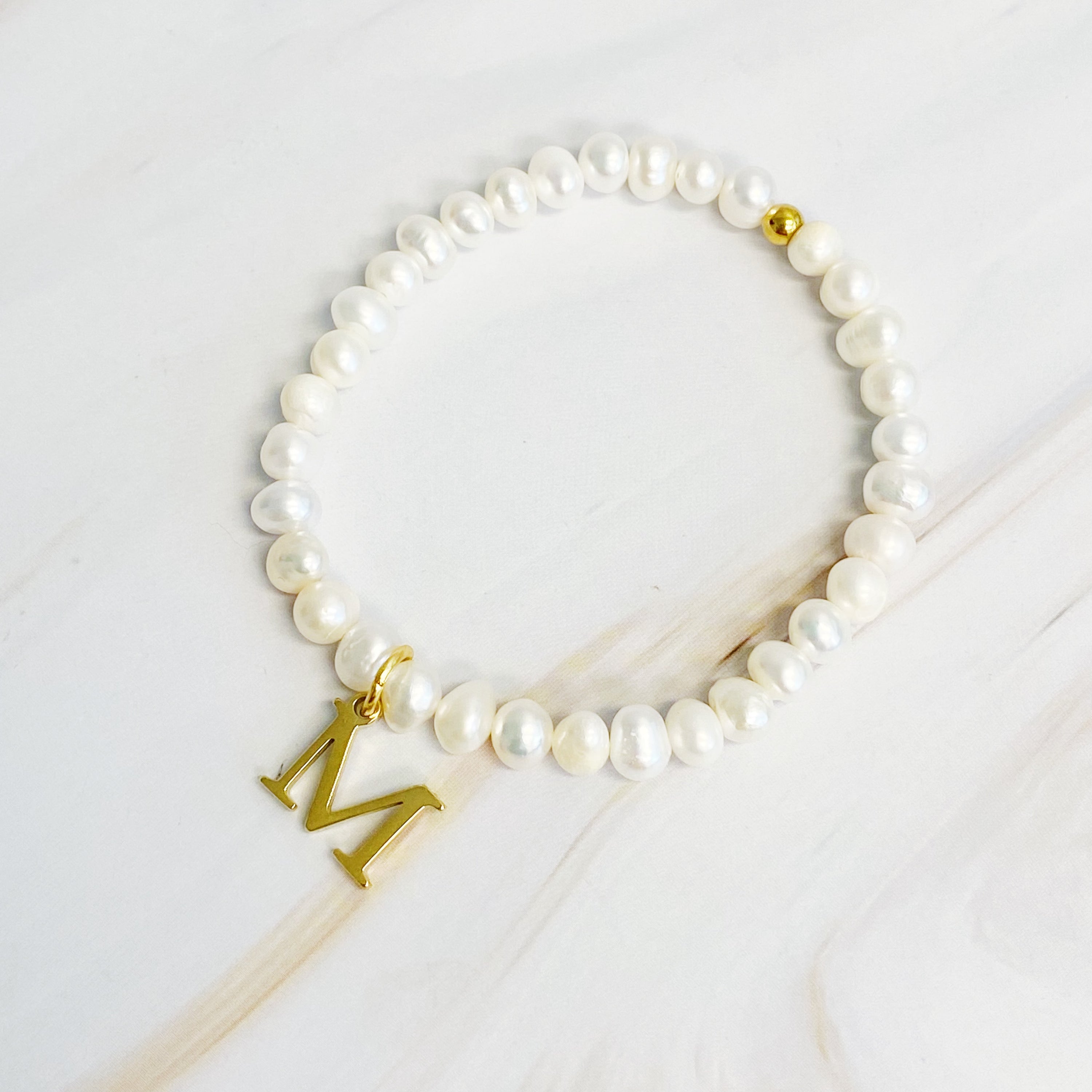 A stylish Freshwater Pearl Initial Charm Bracelet featuring genuine pearls and an 18k gold plated initial charm, perfect for personalized elegance.