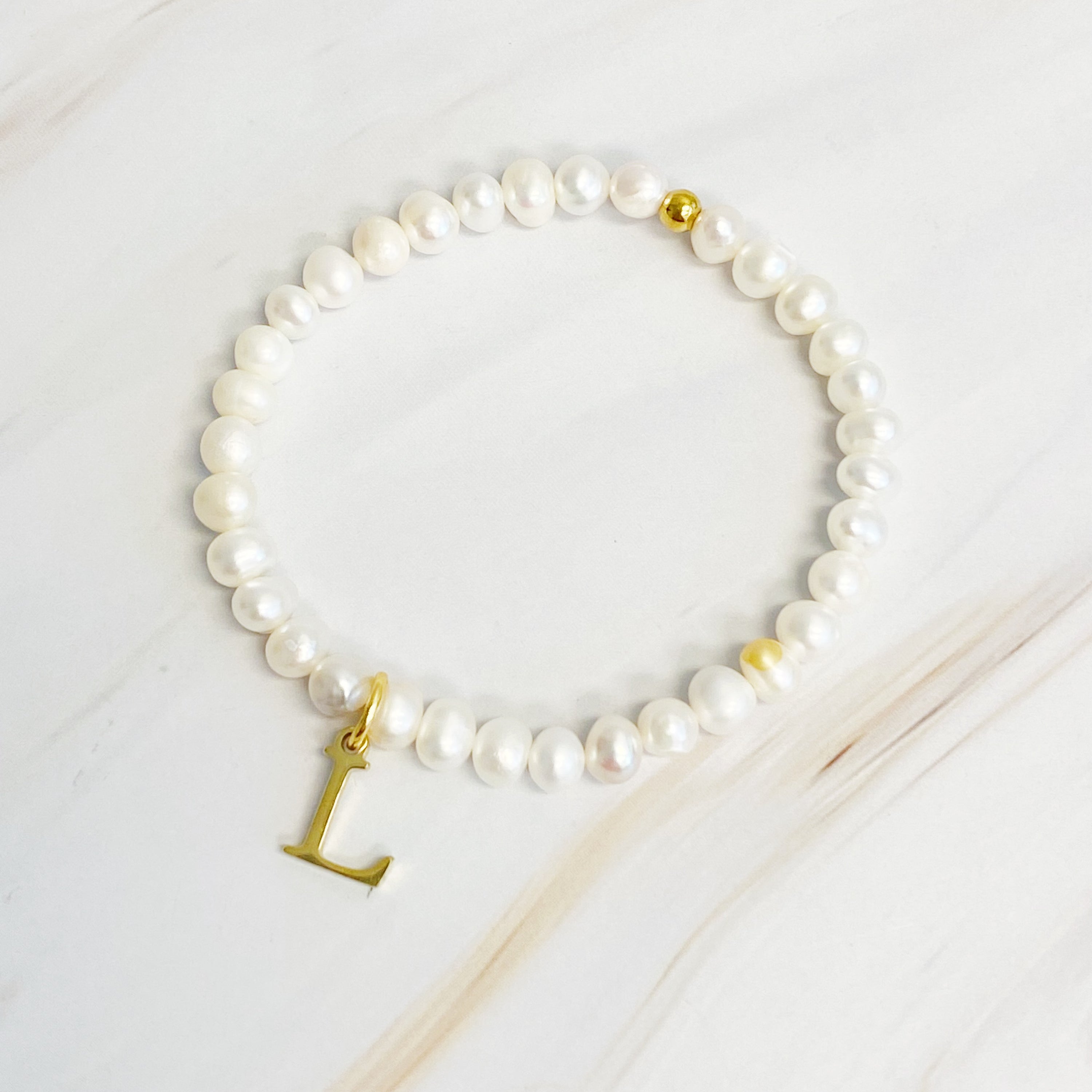 A stylish Freshwater Pearl Initial Charm Bracelet featuring genuine pearls and an 18k gold plated initial charm, perfect for personalized elegance.