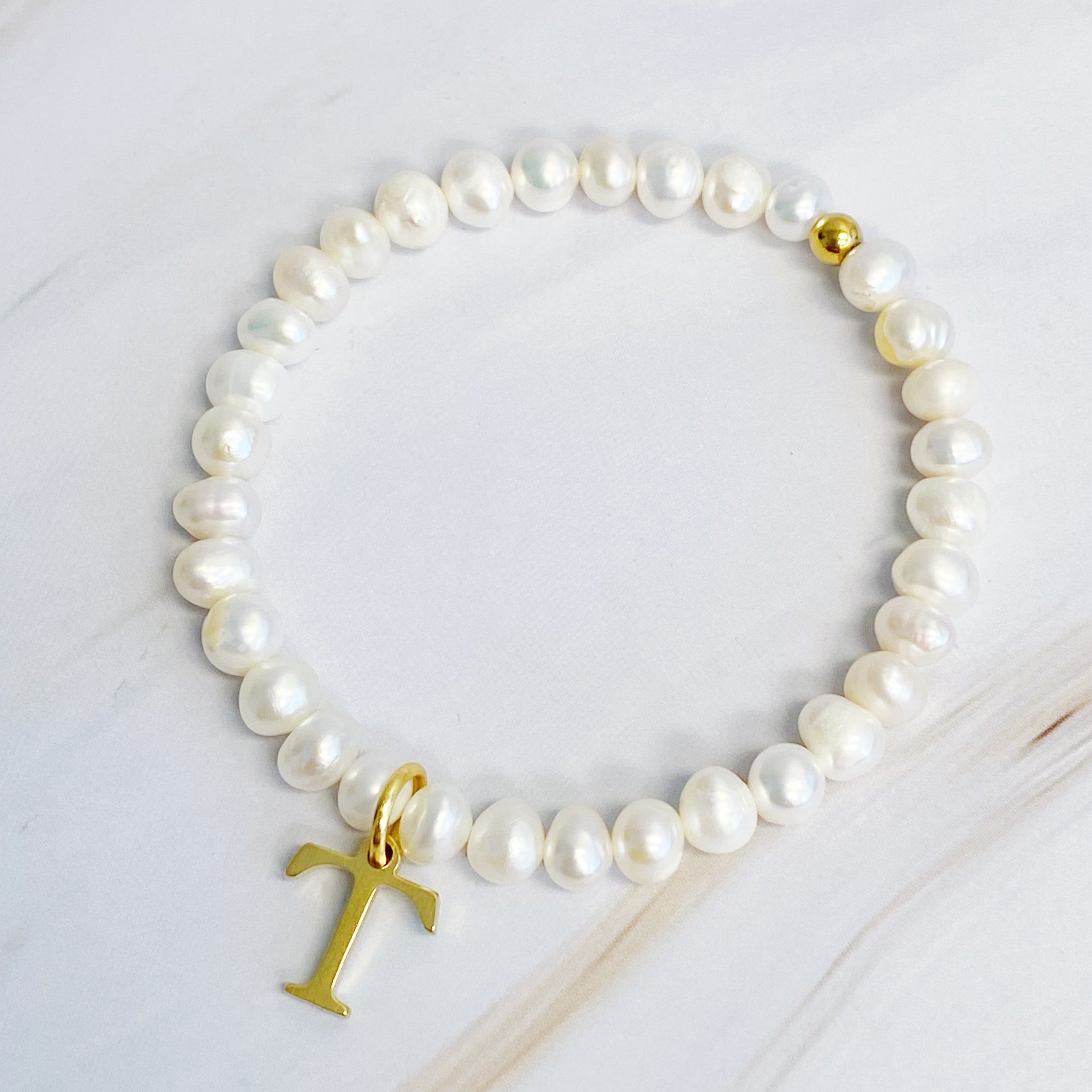 A stylish Freshwater Pearl Initial Charm Bracelet featuring genuine pearls and an 18k gold plated initial charm, perfect for personalized elegance.