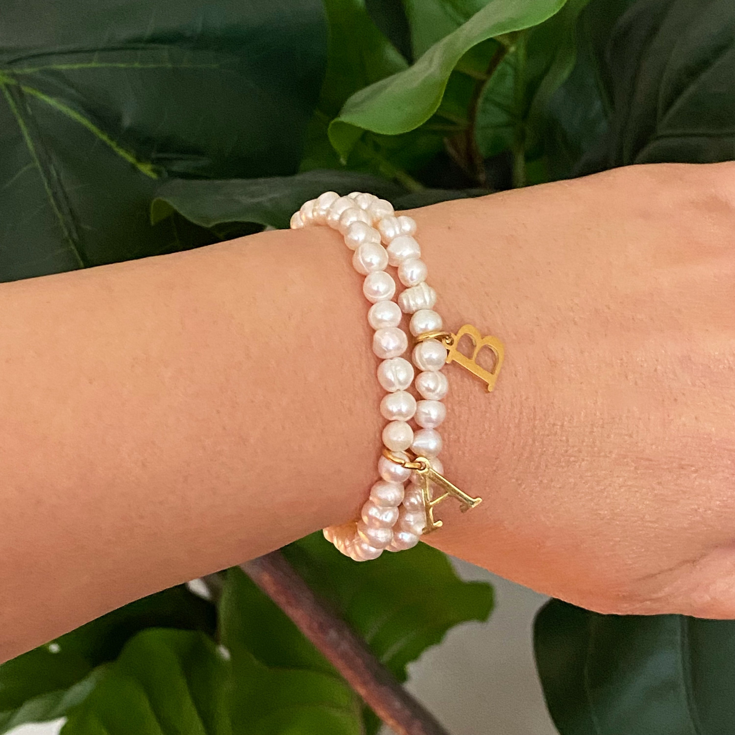 A stylish Freshwater Pearl Initial Charm Bracelet featuring genuine pearls and an 18k gold plated initial charm, perfect for personalized elegance.