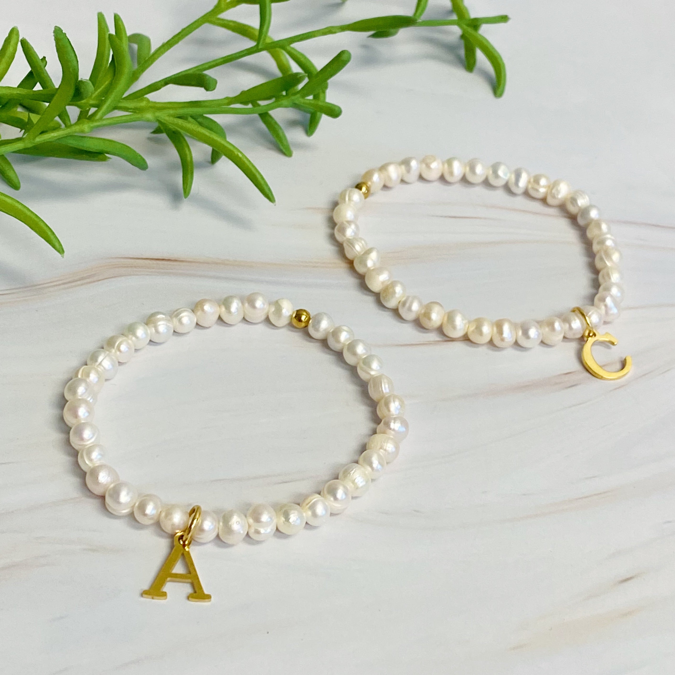 A stylish Freshwater Pearl Initial Charm Bracelet featuring genuine pearls and an 18k gold plated initial charm, perfect for personalized elegance.