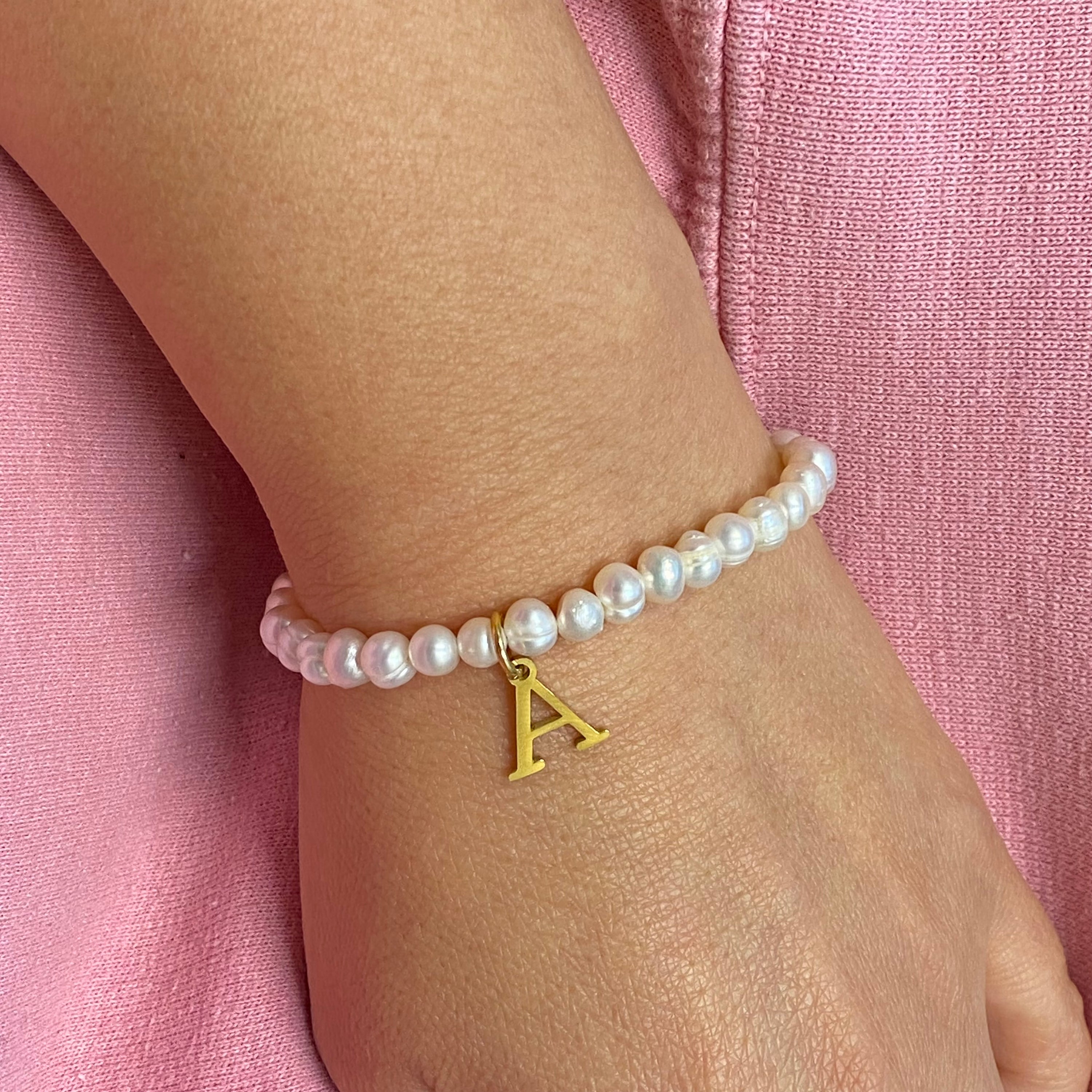 A stylish Freshwater Pearl Initial Charm Bracelet featuring genuine pearls and an 18k gold plated initial charm, perfect for personalized elegance.