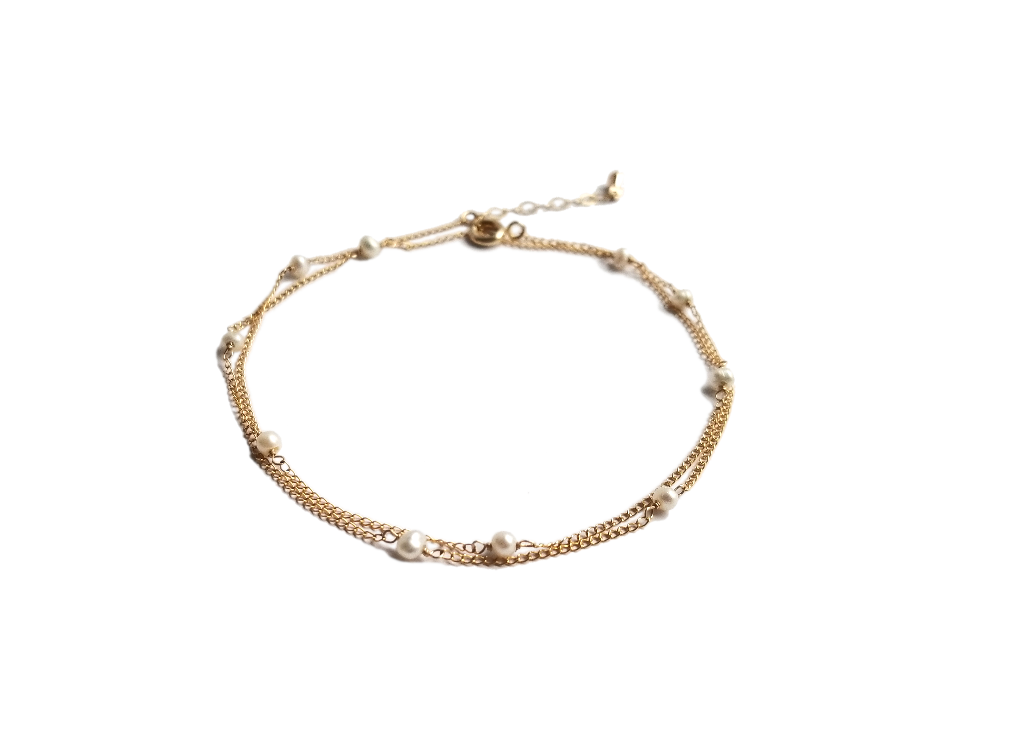 A delicate strand of tiny Freshwater Pearls on a 14KT Gold-filled chain, showcasing its versatility as an anklet, bracelet, or necklace.