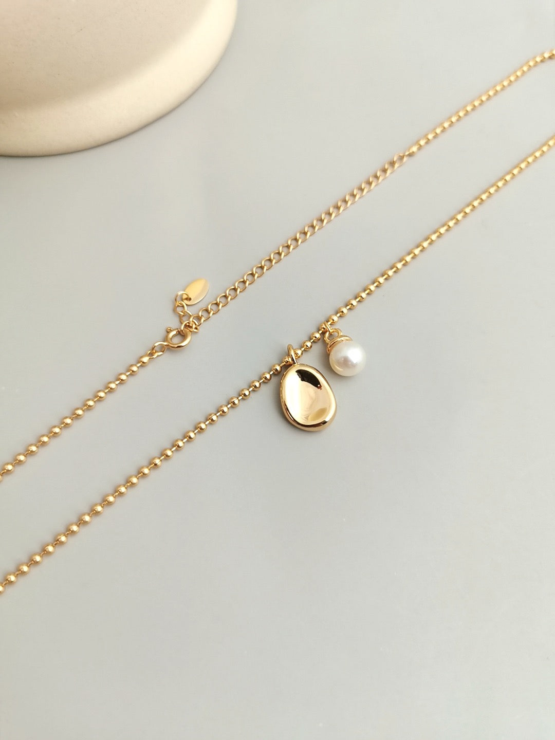 A delicate Freshwater Pearl with Bean Pendant Necklace featuring a natural pearl and gold vermeil chain, elegantly displayed.