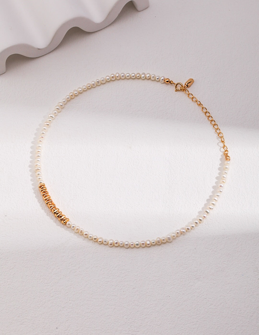 A beautiful Freshwater Pearl Necklace featuring gold vermeil and sterling silver beads, elegantly displayed on a soft fabric background.